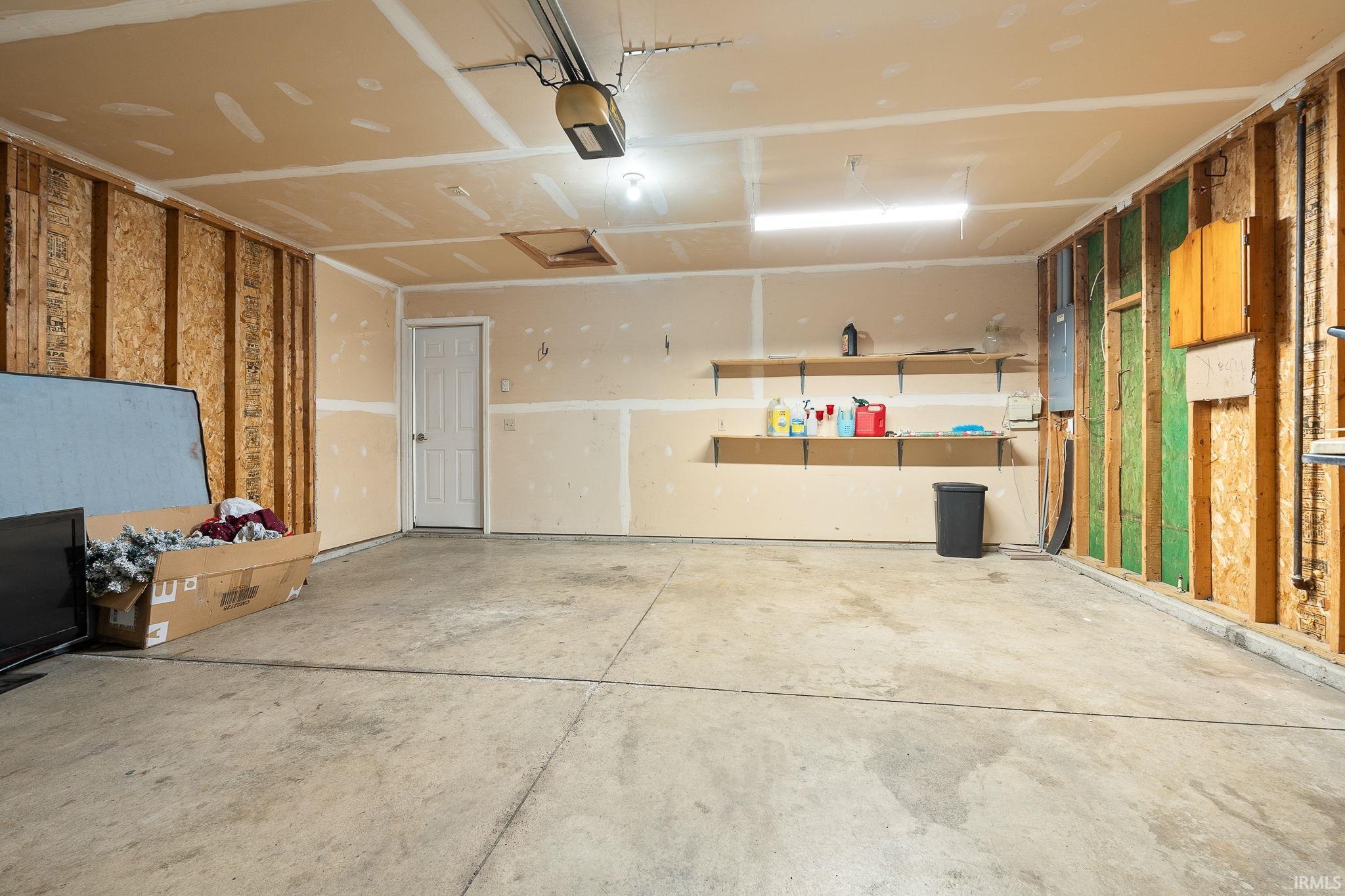 Garage featuring a garage door opener and electric panel
