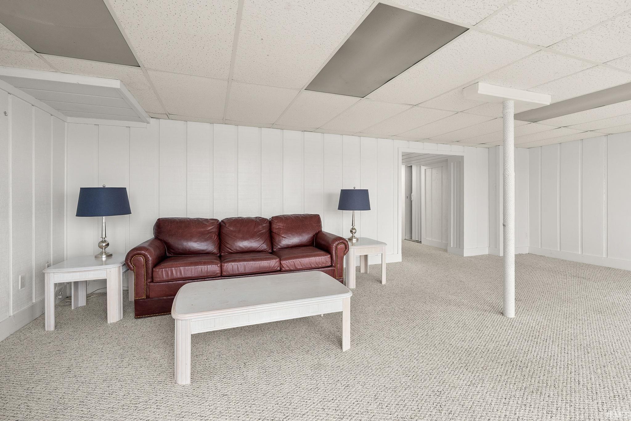 Living room with a paneled ceiling and light carpet