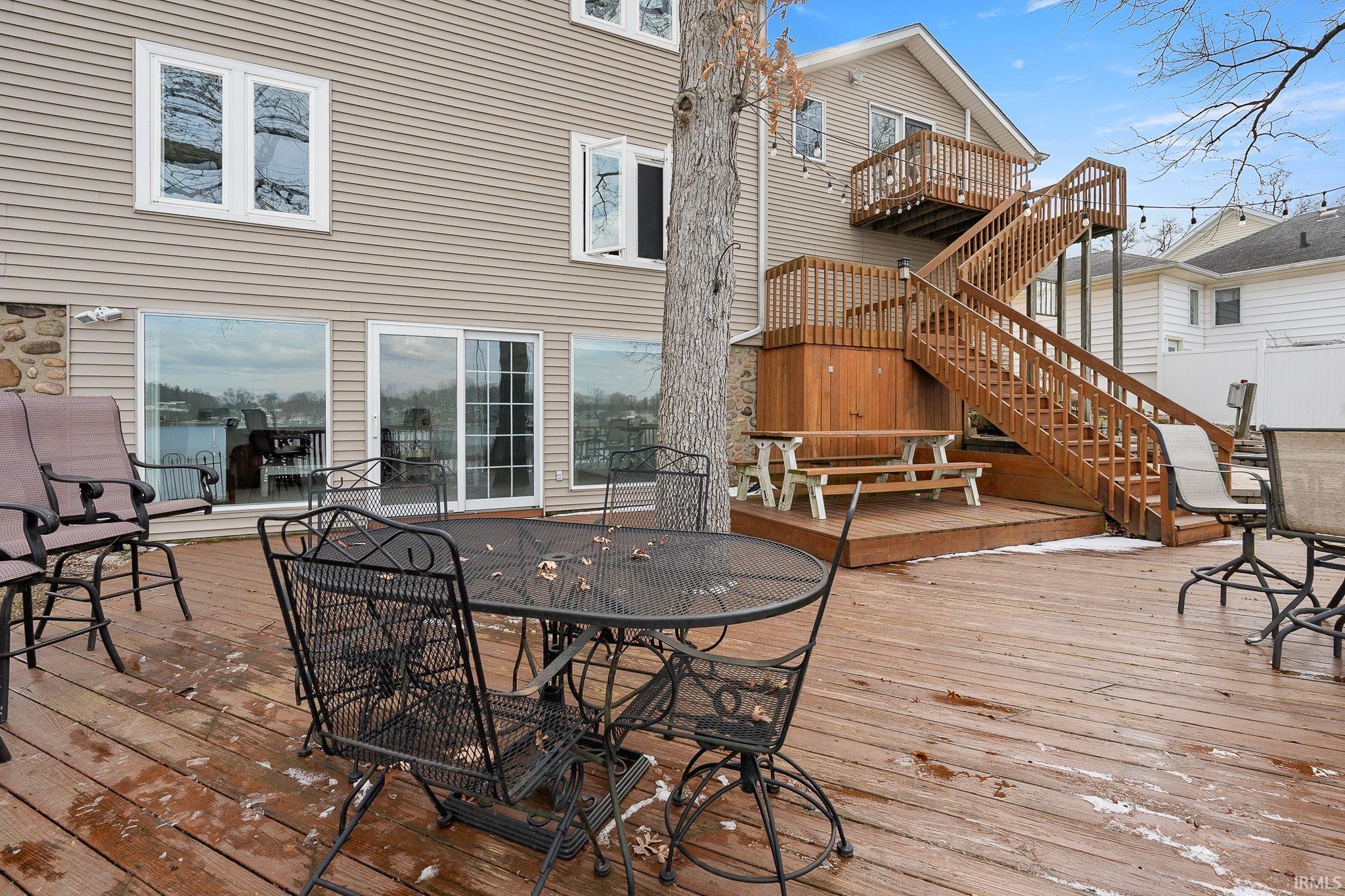 Wooden terrace featuring outdoor dining space and stairs