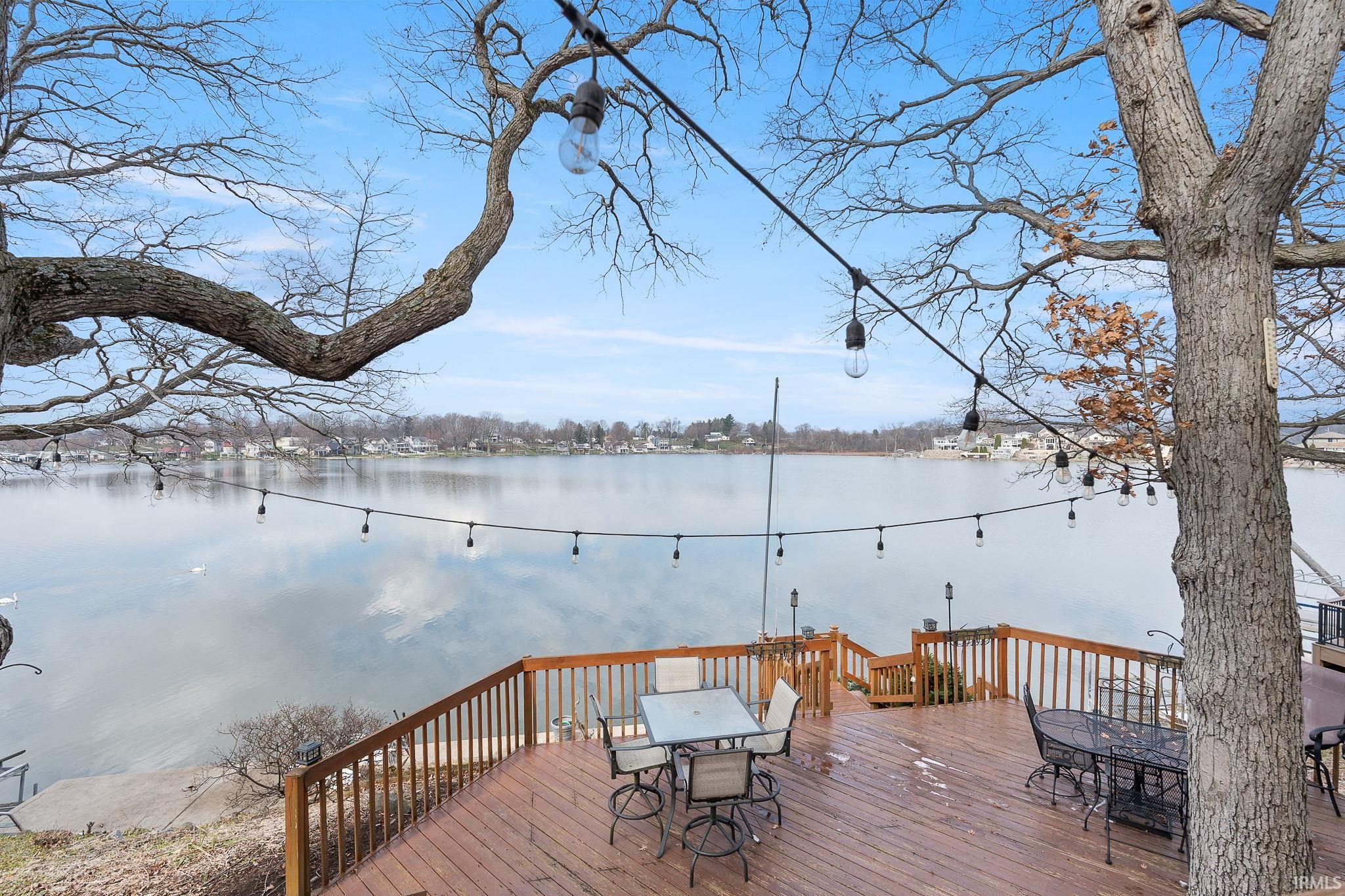 Wooden terrace featuring outdoor dining area and a water view