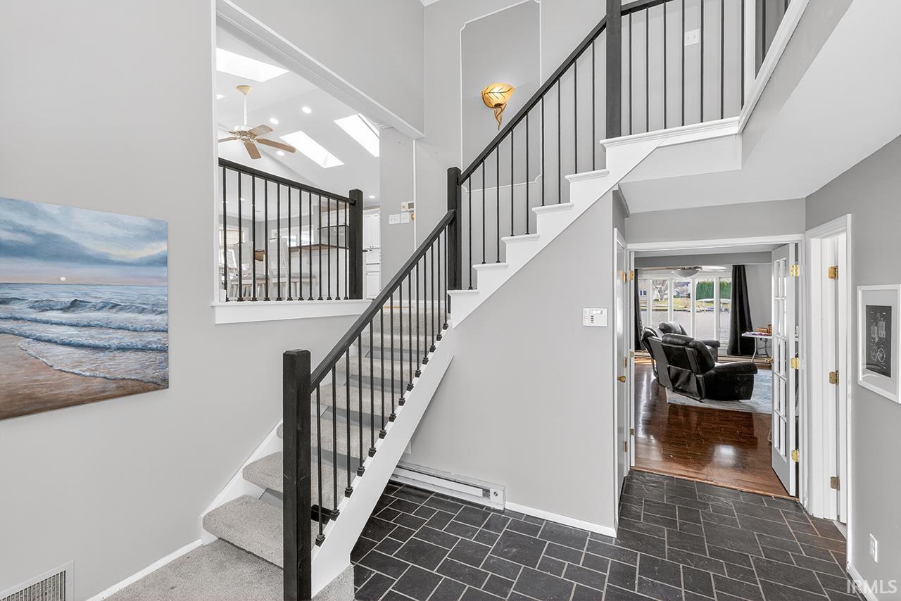 Stairs featuring a ceiling fan and a high ceiling