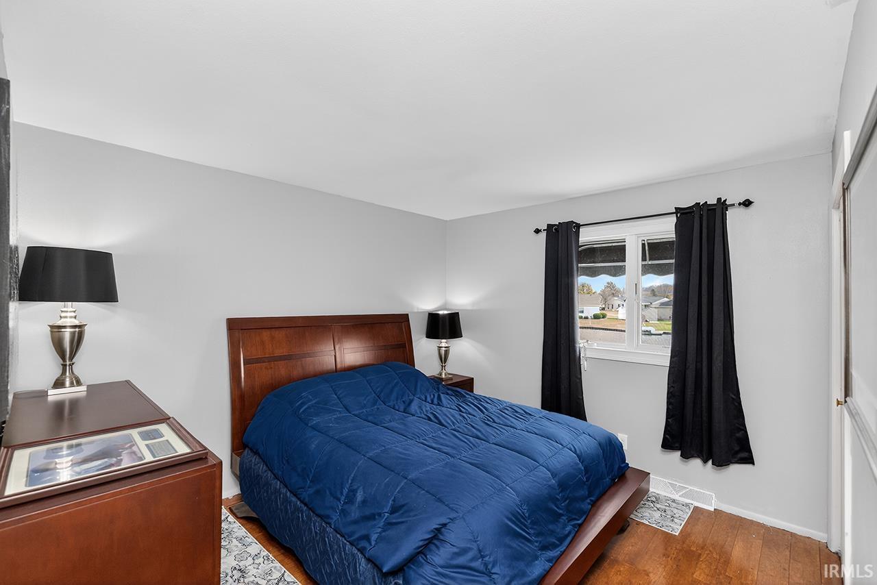 Bedroom featuring wood finished floors and baseboards