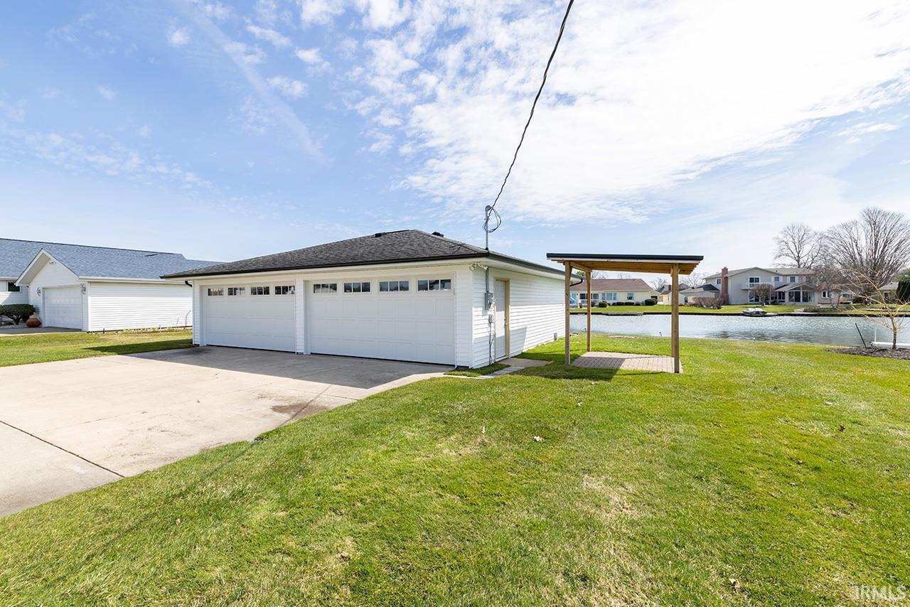 Detached garage with a water view and a residential view