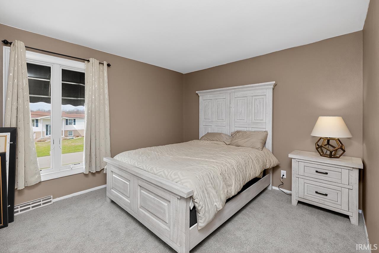 Bedroom featuring baseboards and light colored carpet