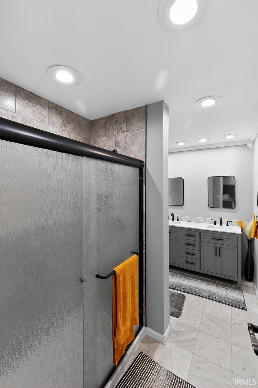 Bathroom featuring double vanity and a shower stall