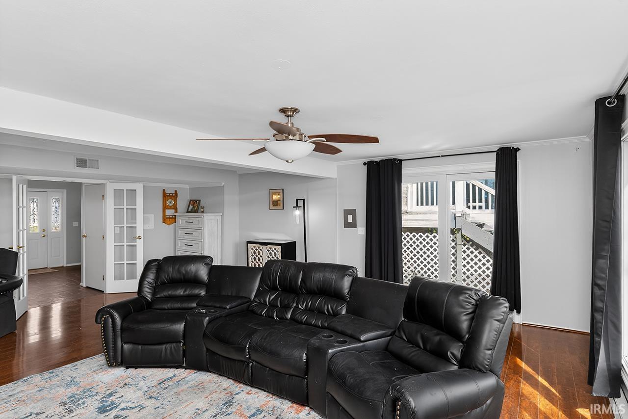 Home theater with plenty of natural light, dark wood-style floors, and a ceiling fan