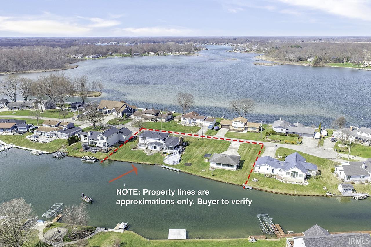 Aerial perspective of suburban area featuring a nearby body of water and property boundaries highlighted