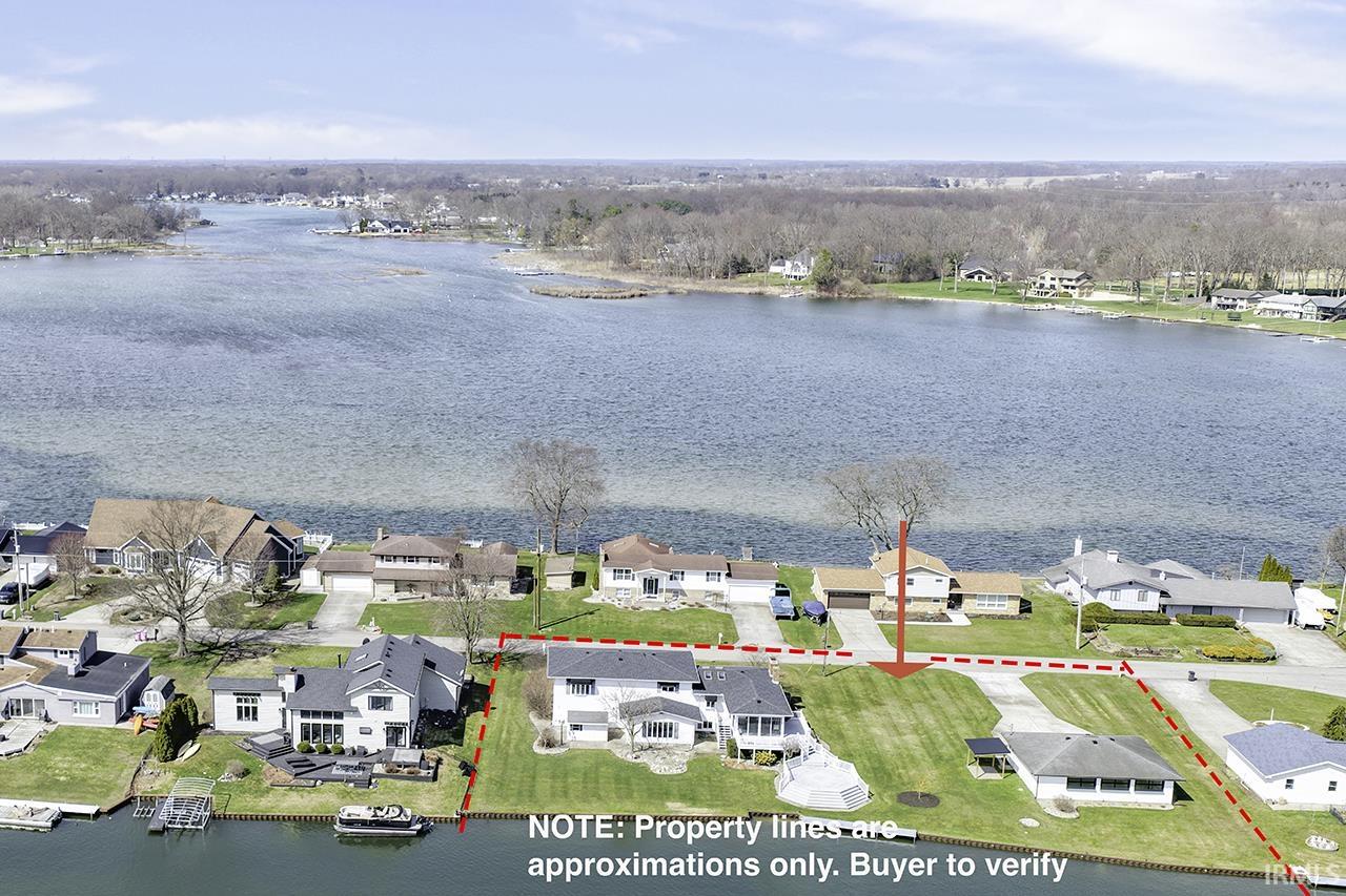 Aerial view of residential area with a nearby body of water and property boundaries highlighted