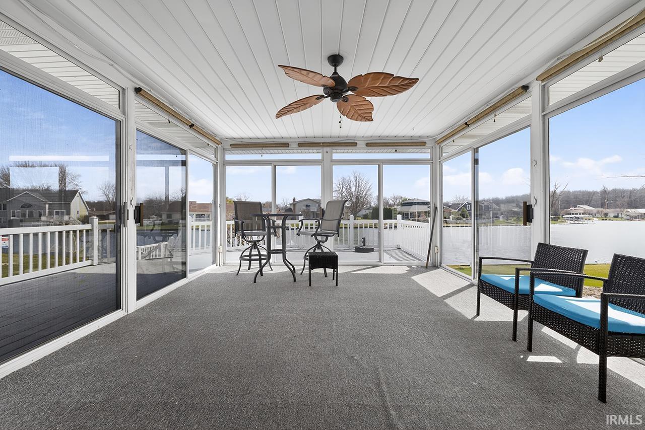 Sunroom / solarium with a ceiling fan and a residential view