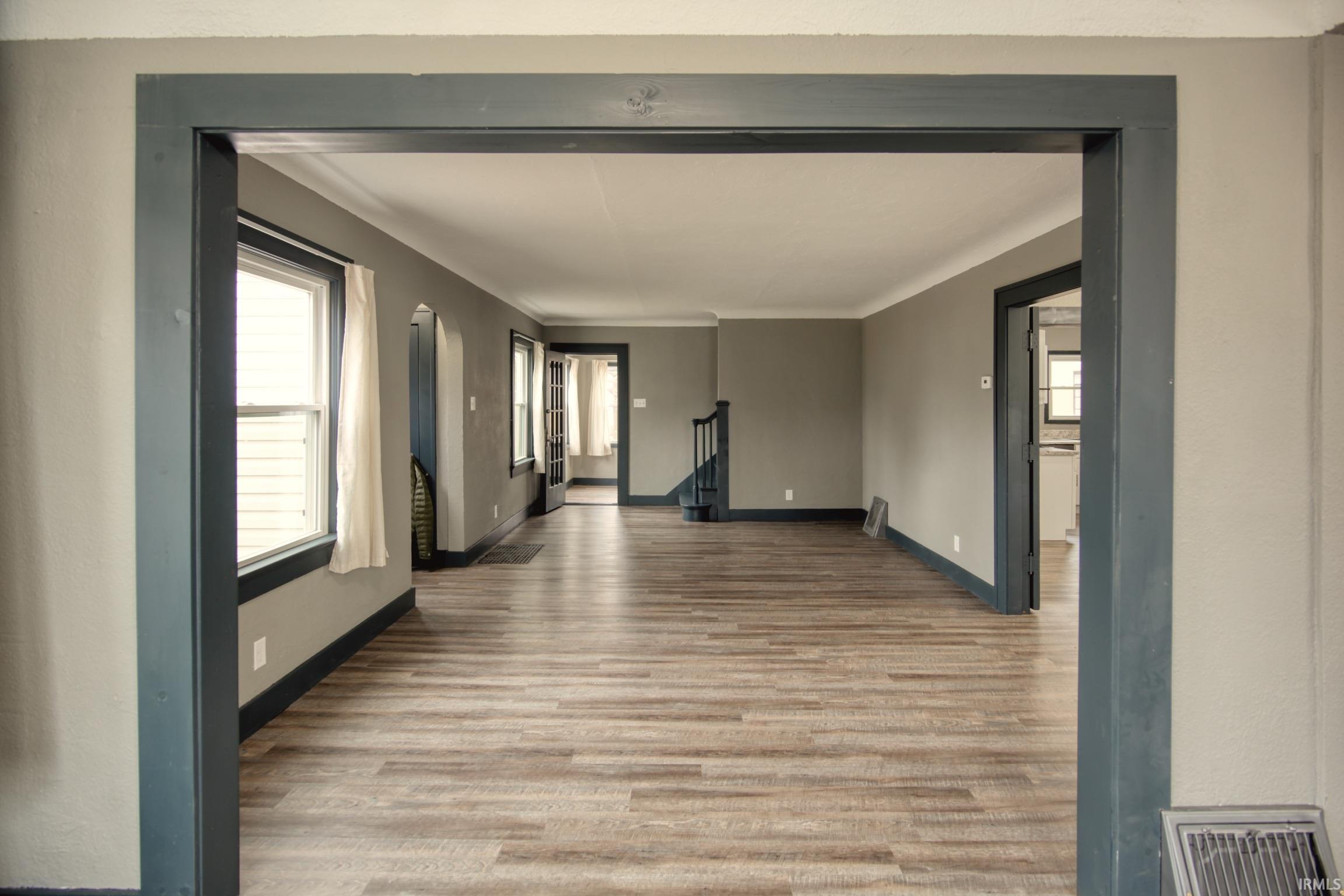 Empty room featuring plenty of natural light, light wood finished floors, and stairs