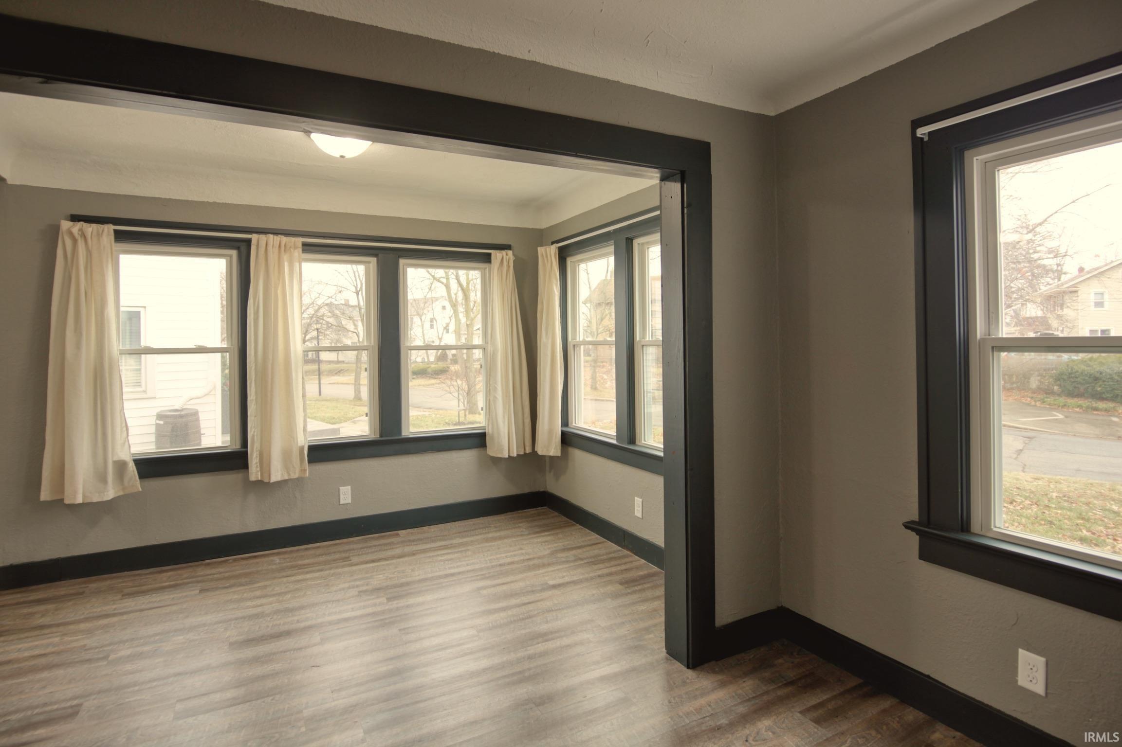 Spare room with wood finished floors and healthy amount of natural light