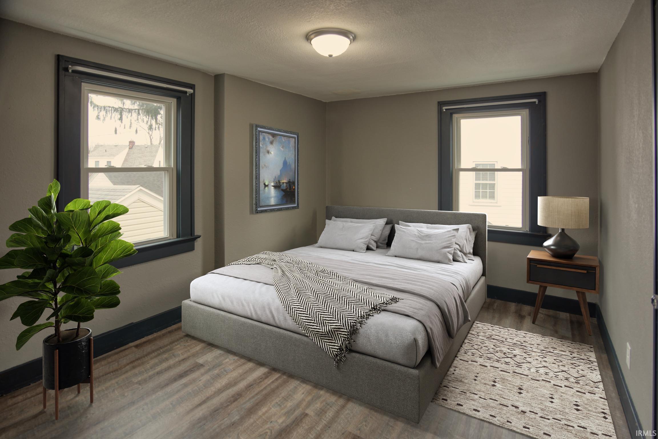 Bedroom featuring wood finished floors, a textured ceiling, and multiple windows