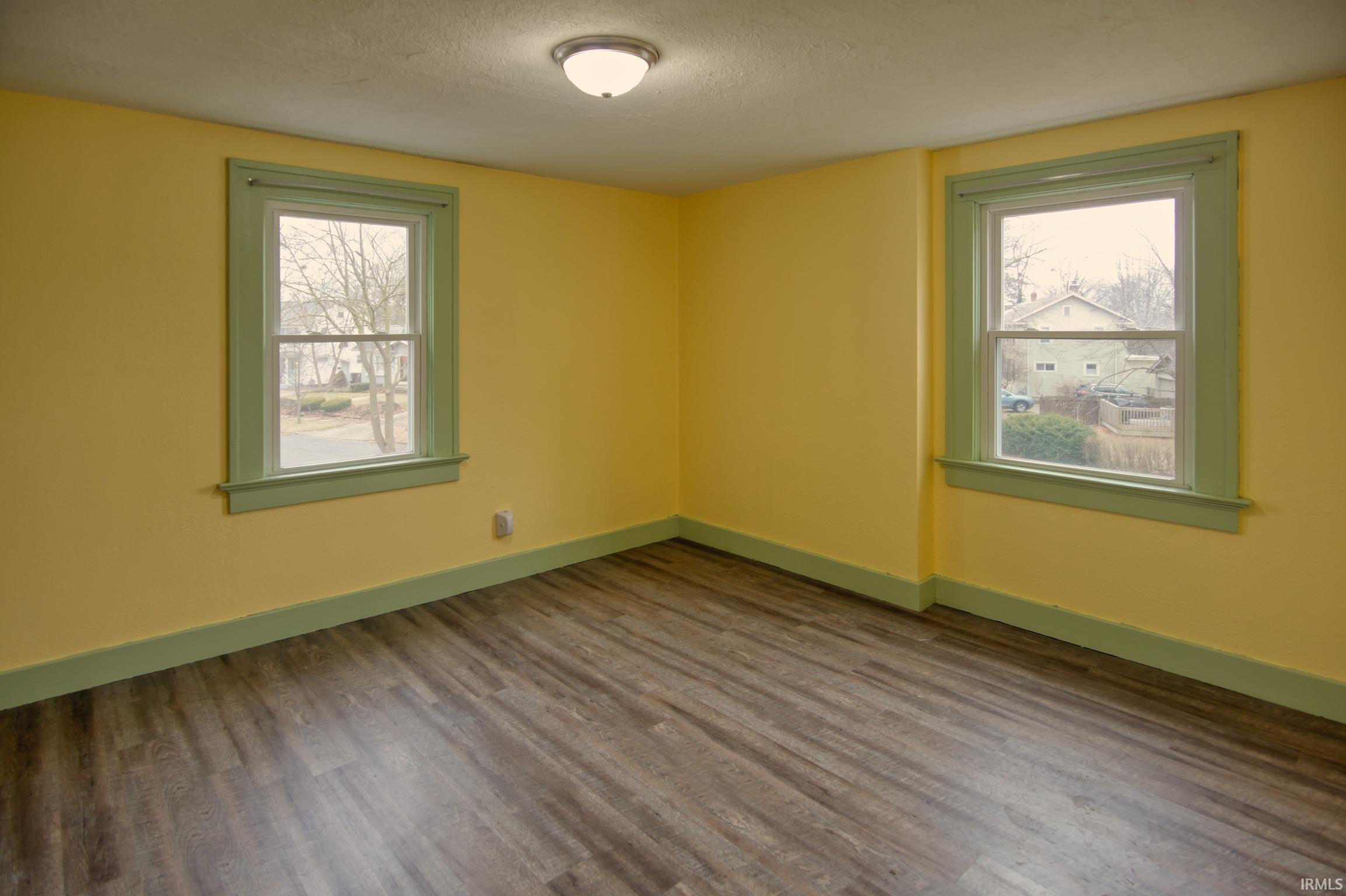 Spare room featuring a textured ceiling, wood finished floors, and plenty of natural light