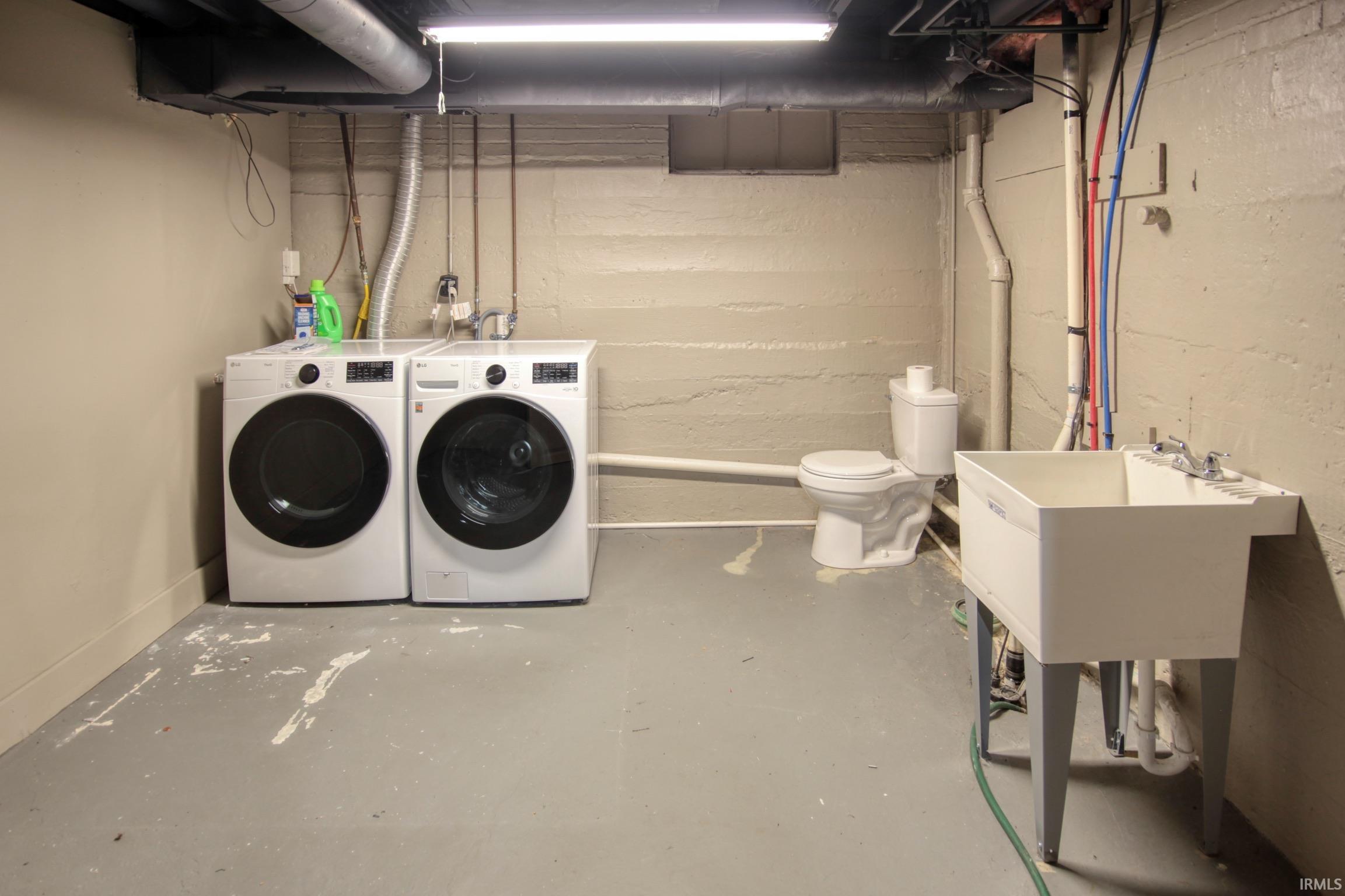 Laundry area with concrete floors and washing machine and dryer