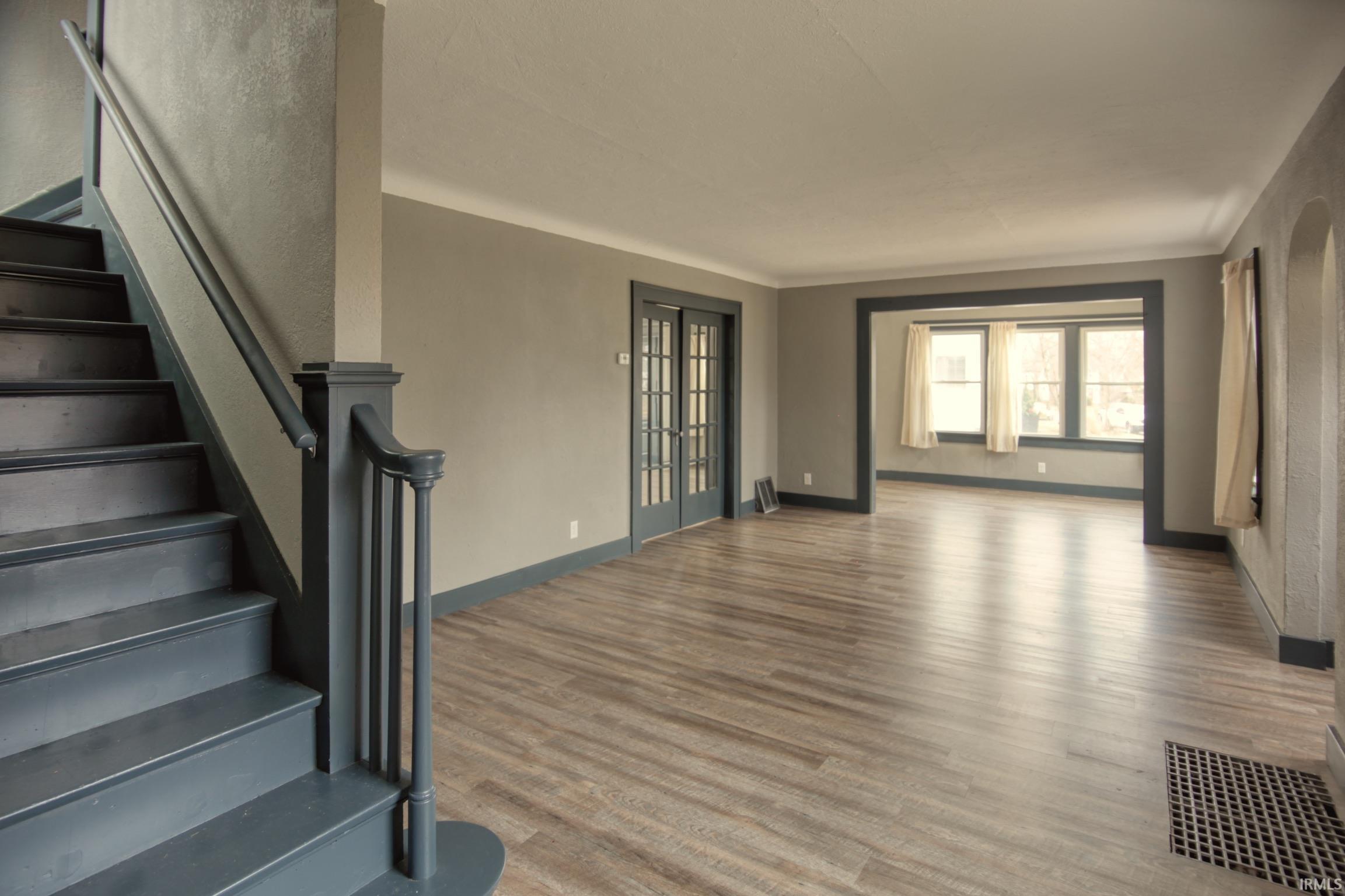 Staircase with wood finished floors and french doors