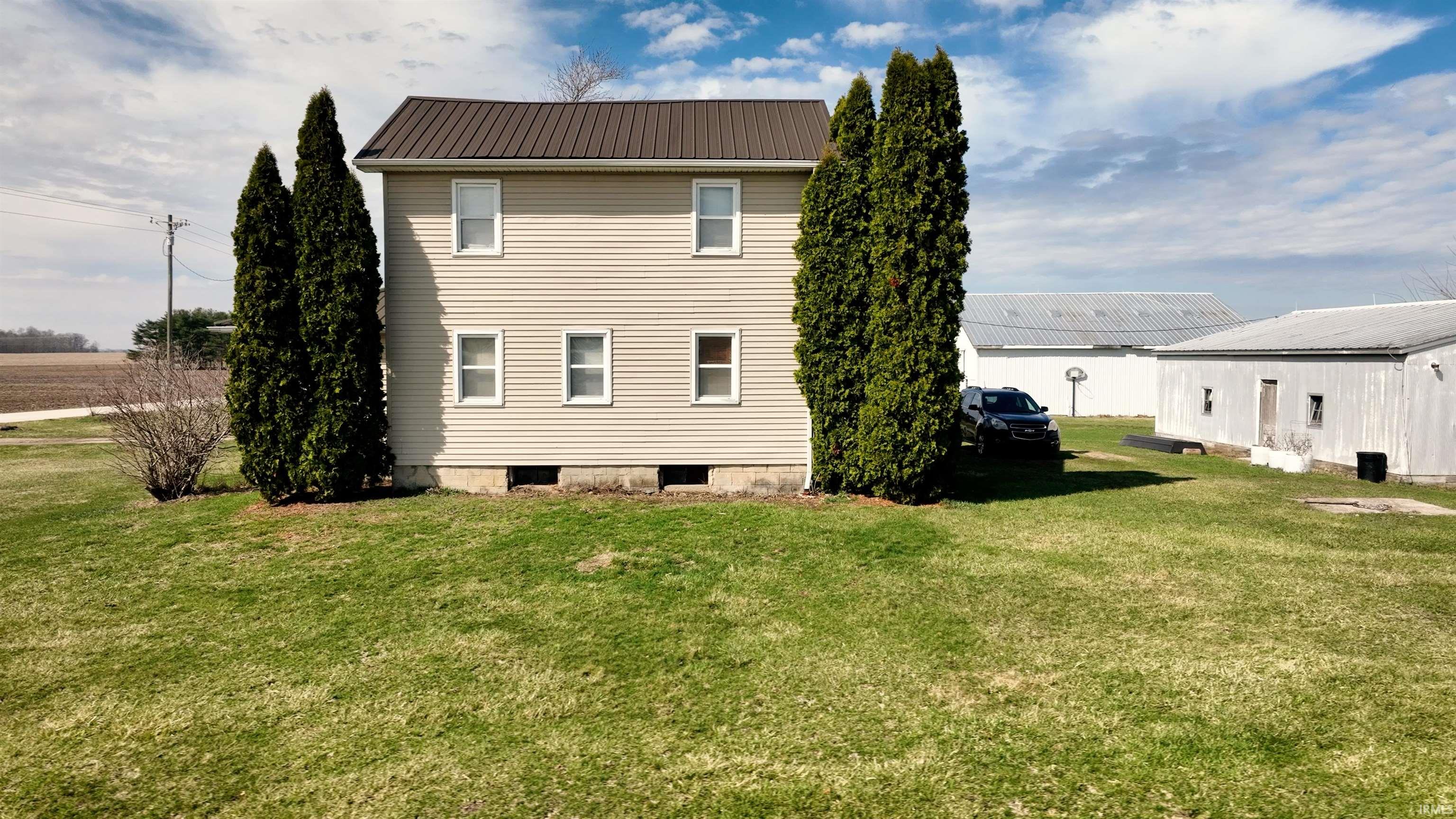 Back of property with a yard and a metal roof