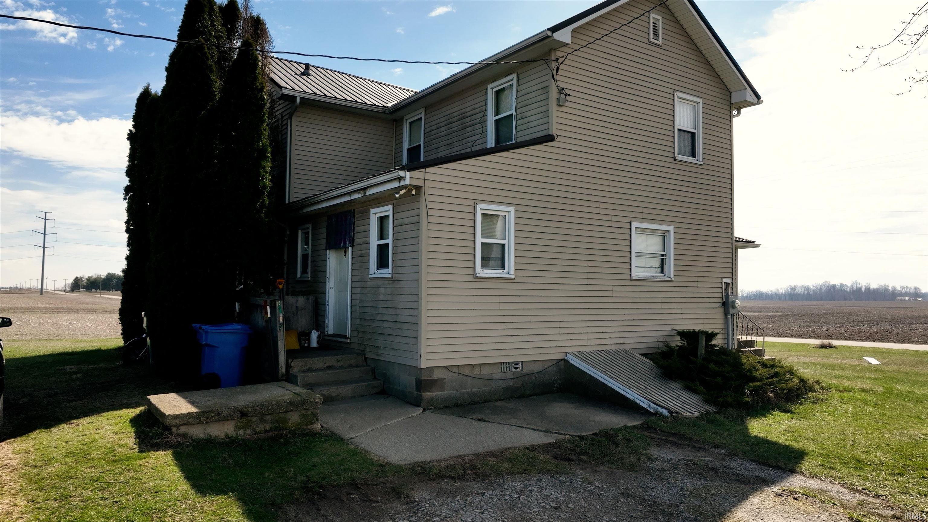 View of side of home featuring a metal roof and a lawn