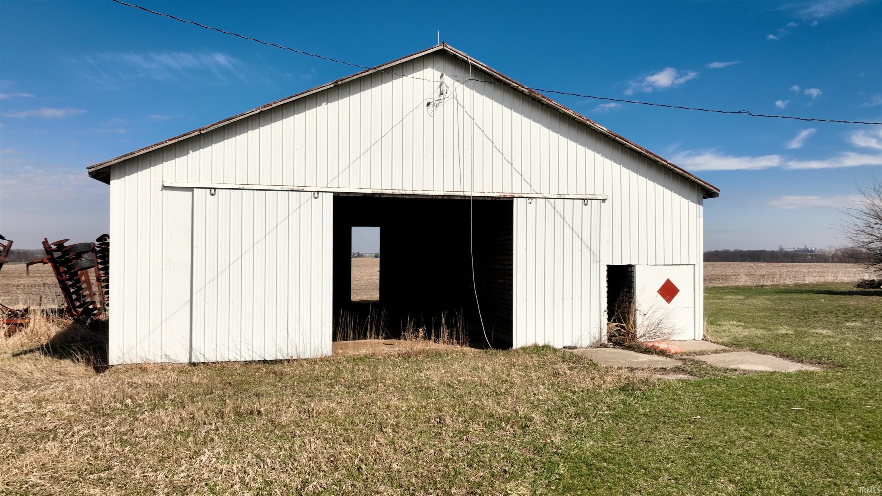 View of pole building featuring a lawn and a view of countryside