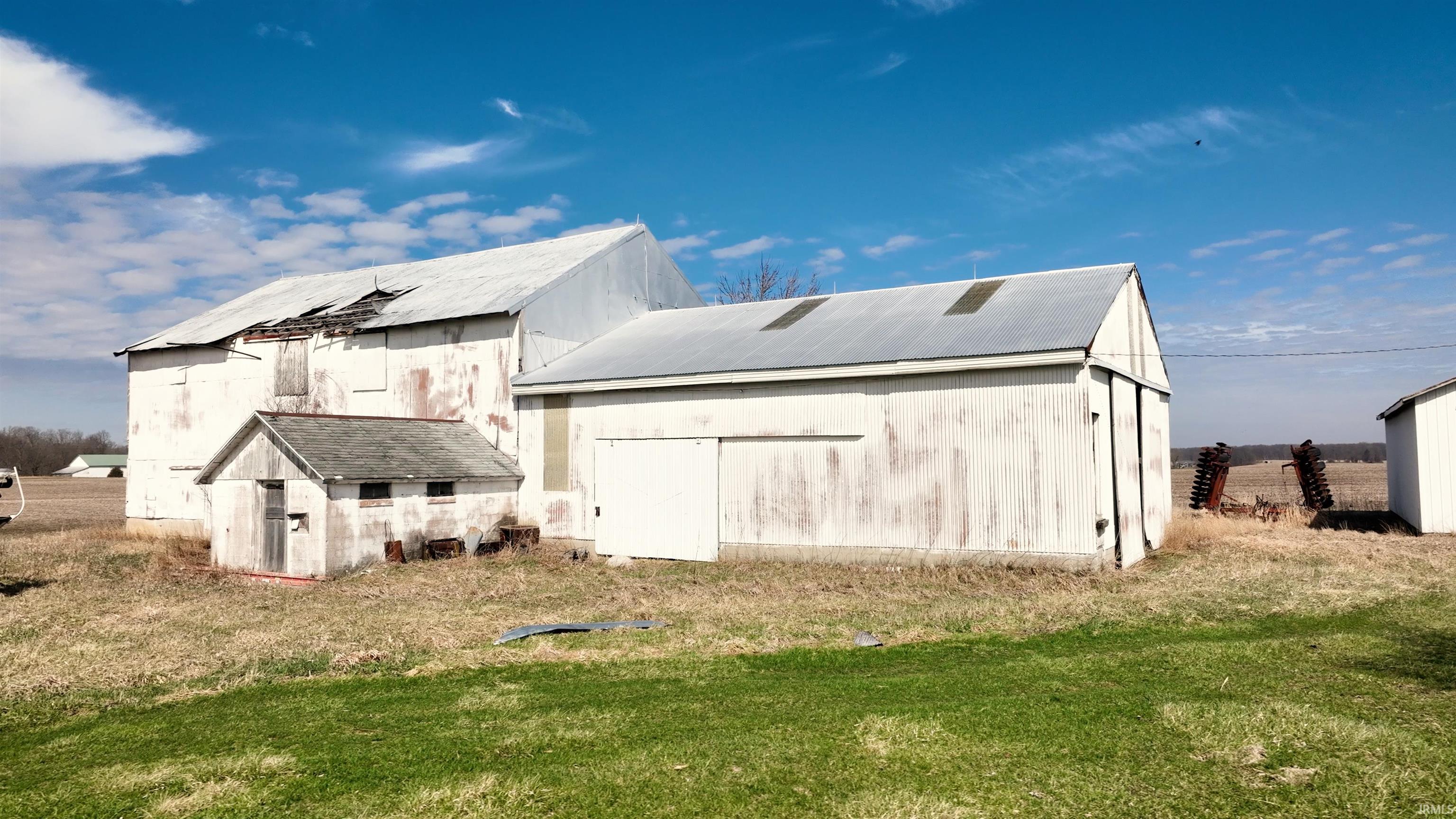 Rear view of property featuring an outbuilding, a lawn, and a metal roof