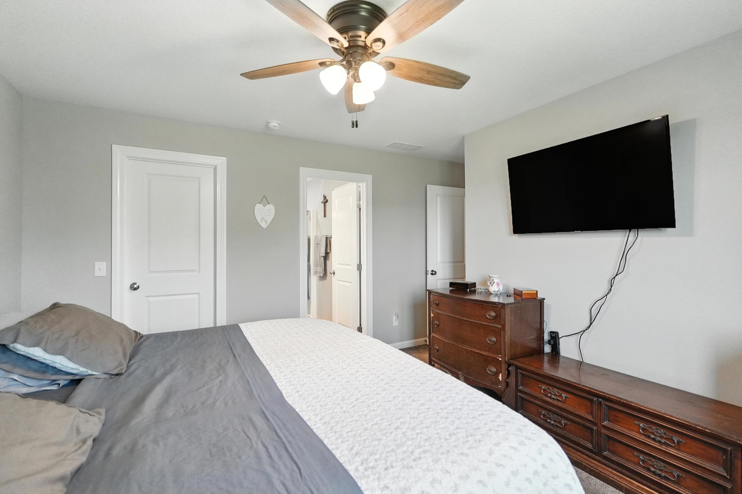 Bedroom featuring ceiling fan and connected bathroom