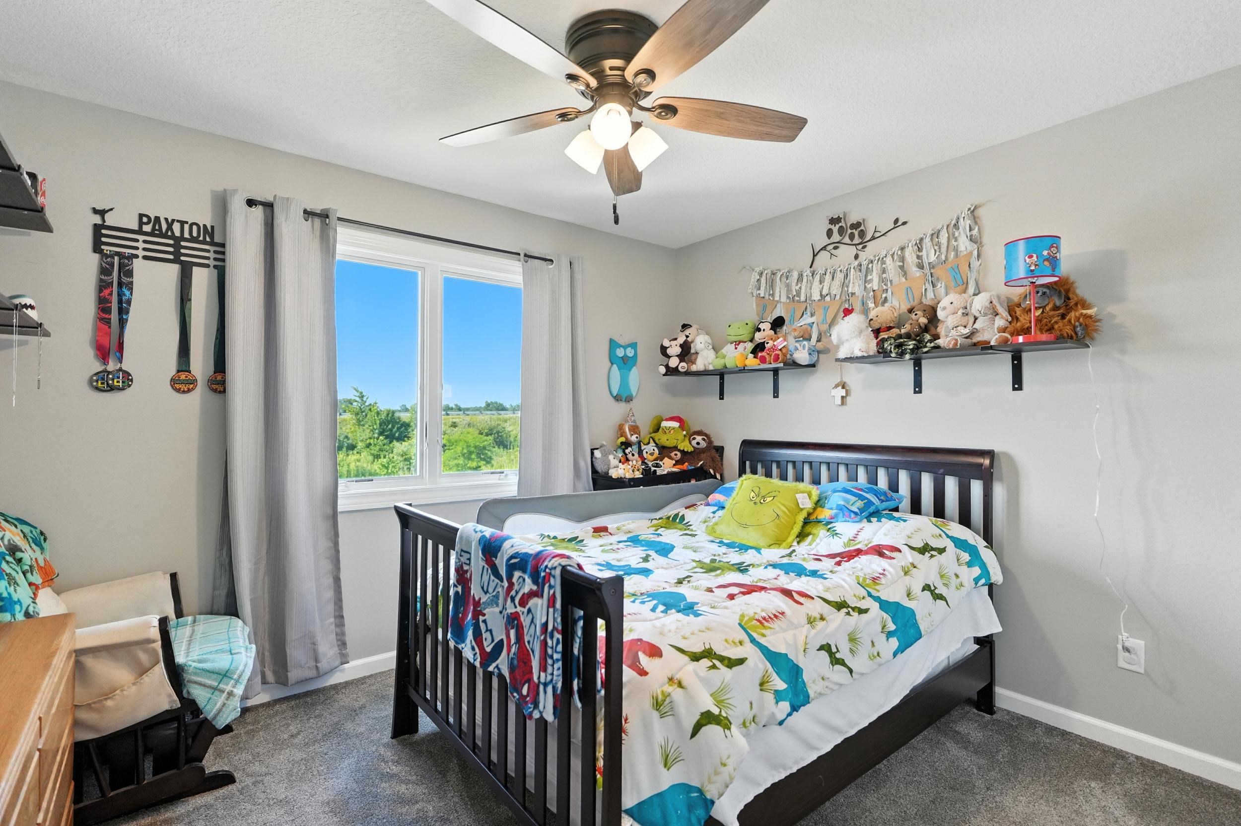 Bedroom with dark colored carpet and a ceiling fan