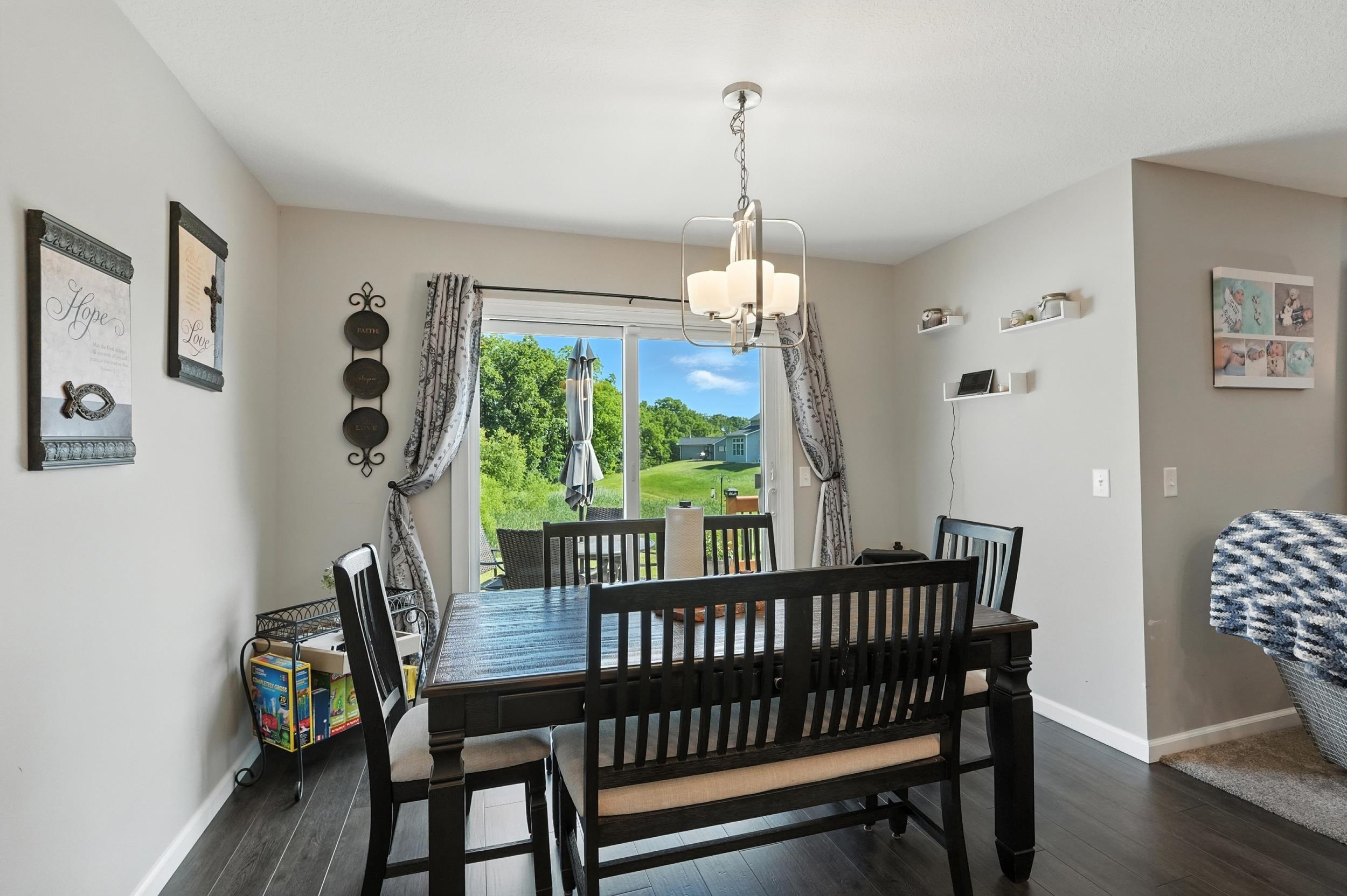 Dining area featuring dark wood-style flooring and a chandelier