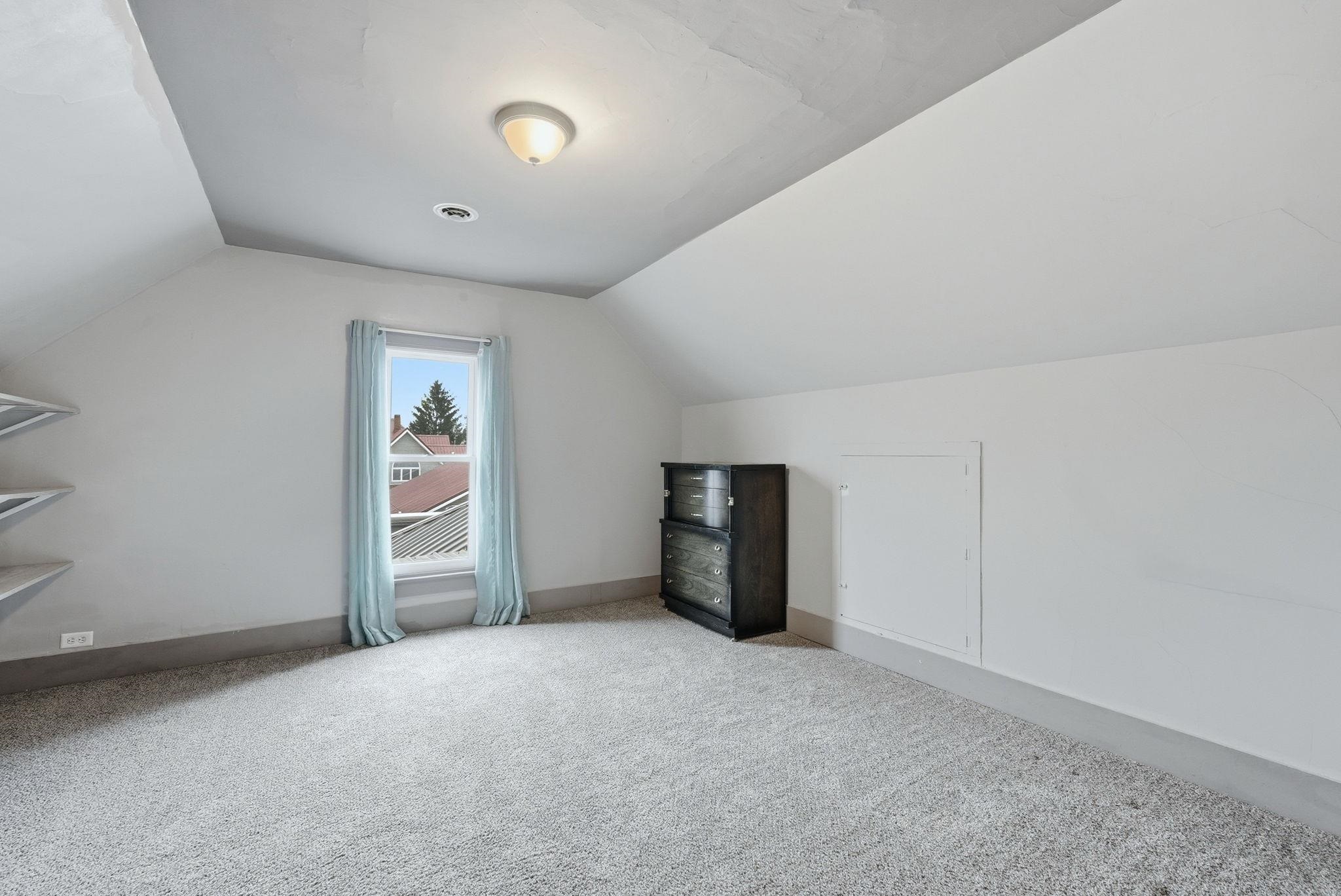 Additional living space featuring light colored carpet and baseboards
