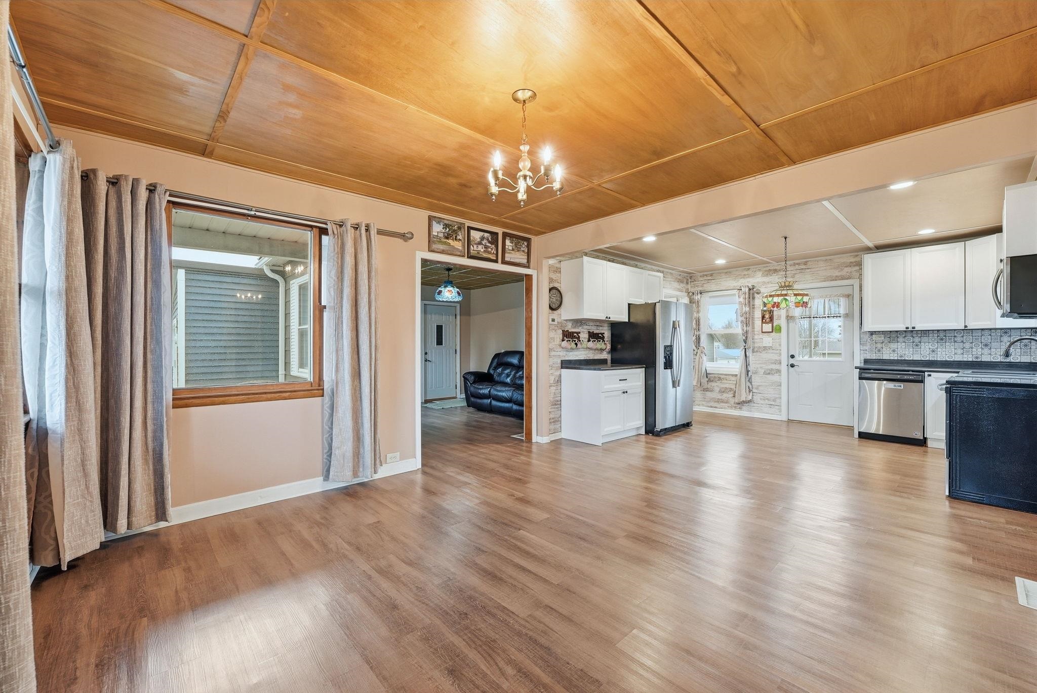 Unfurnished living room featuring wooden ceiling, hanging lights, light wood-type flooring, and ceiling fan