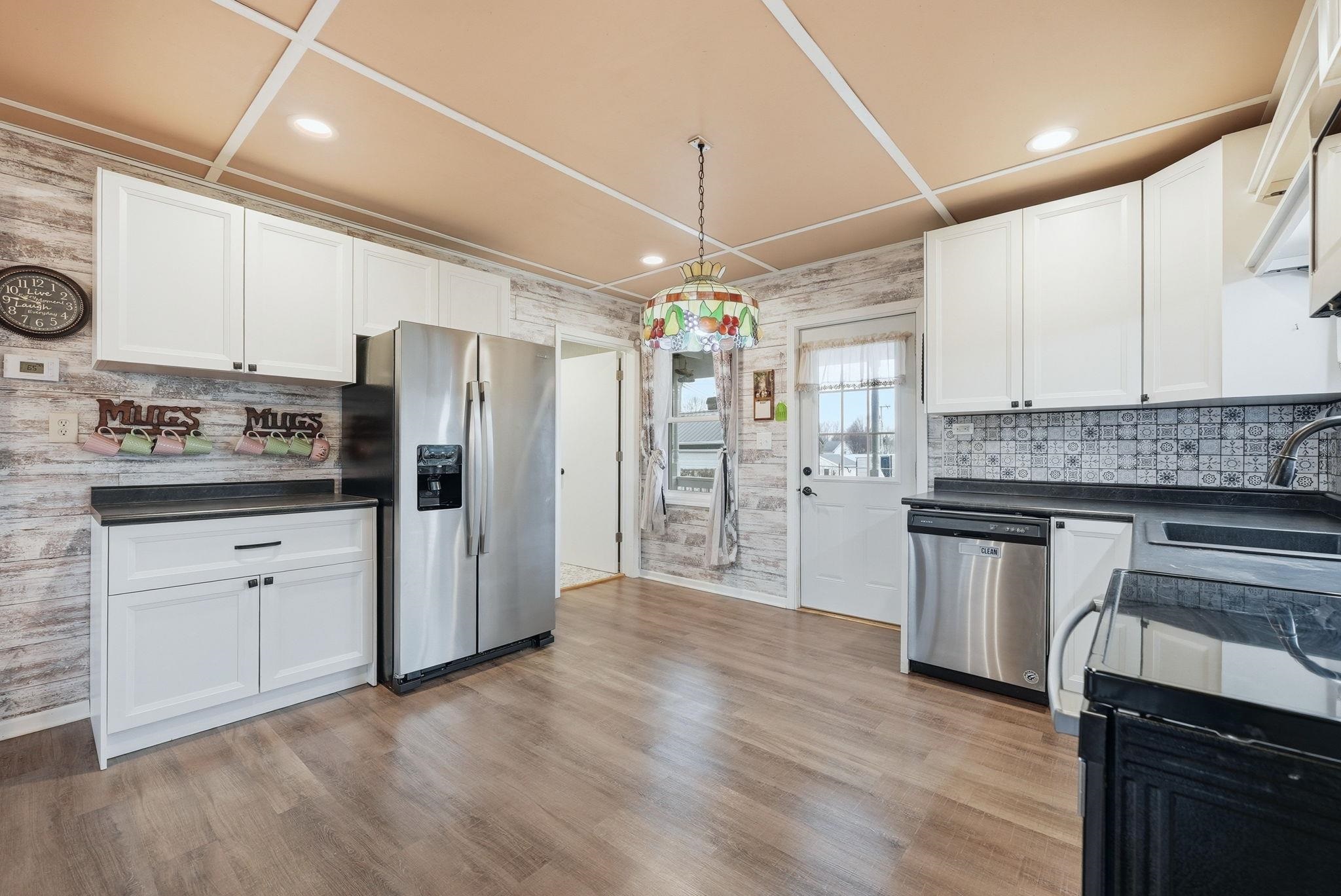 Kitchen featuring stainless steel appliances, white cabinets, light wood-type flooring, and recessed lighting