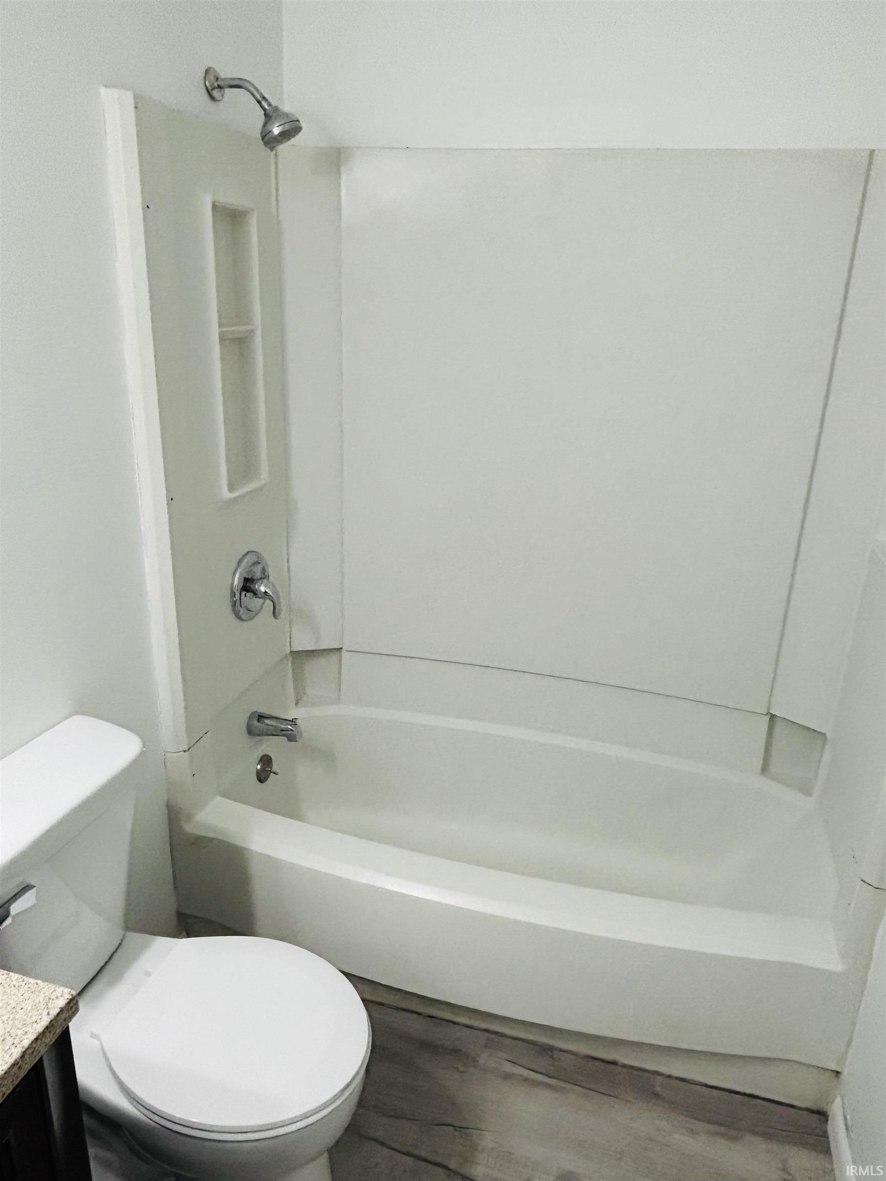 Bathroom with vanity, bathtub / shower combination, and dark wood-type flooring