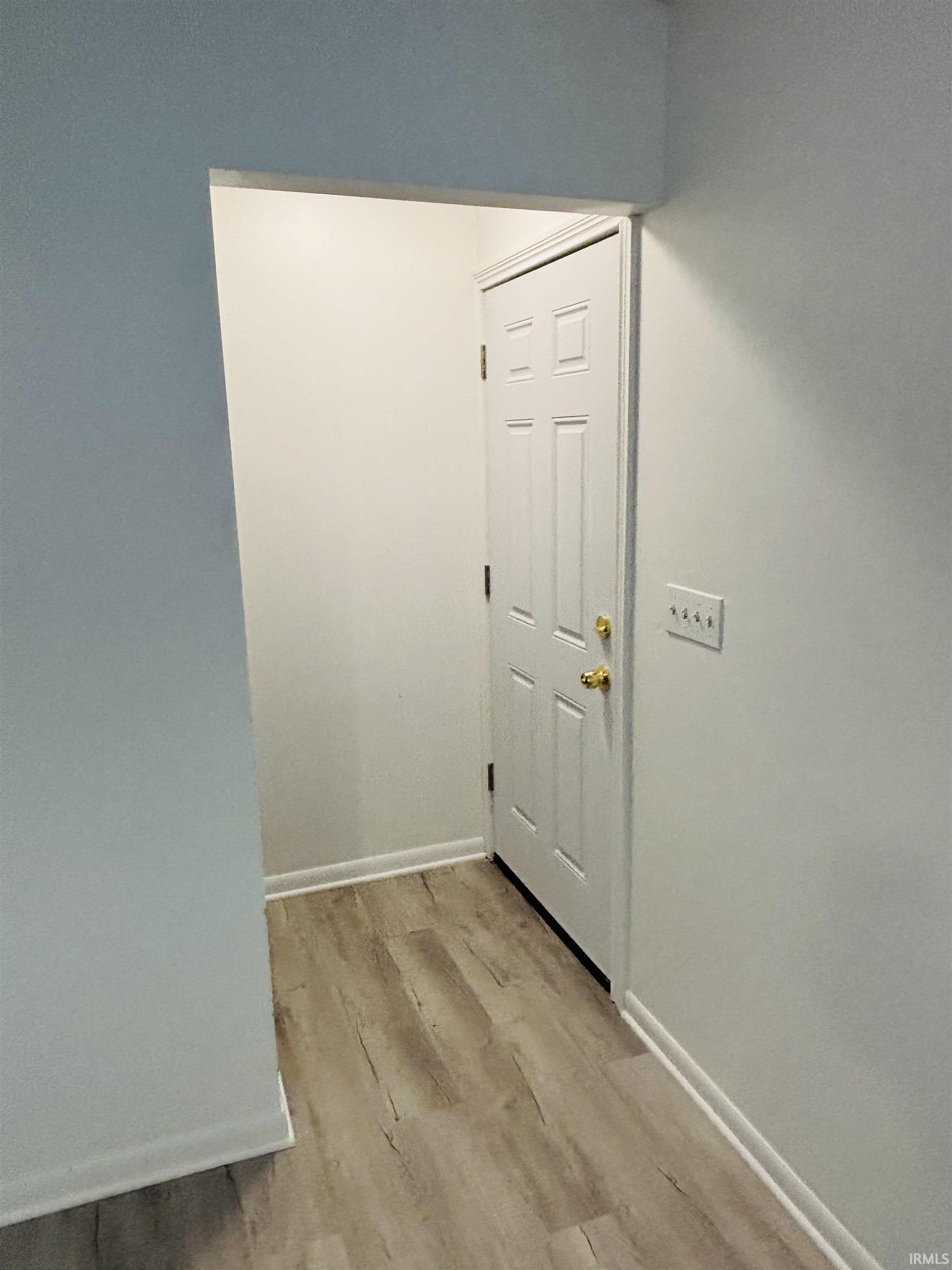 Hallway featuring light wood-style flooring and baseboards