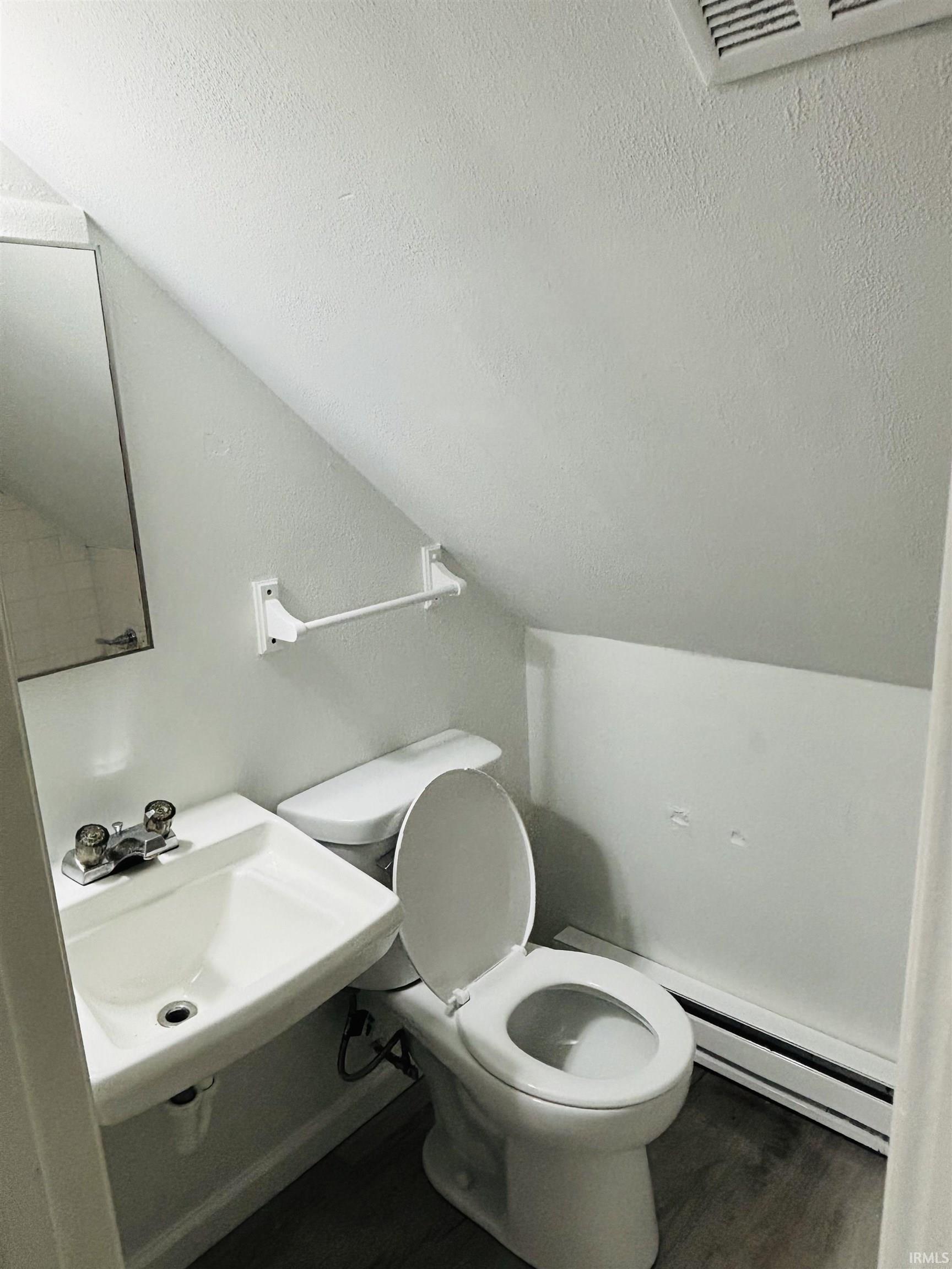 Bathroom featuring a baseboard radiator and wood finished floors