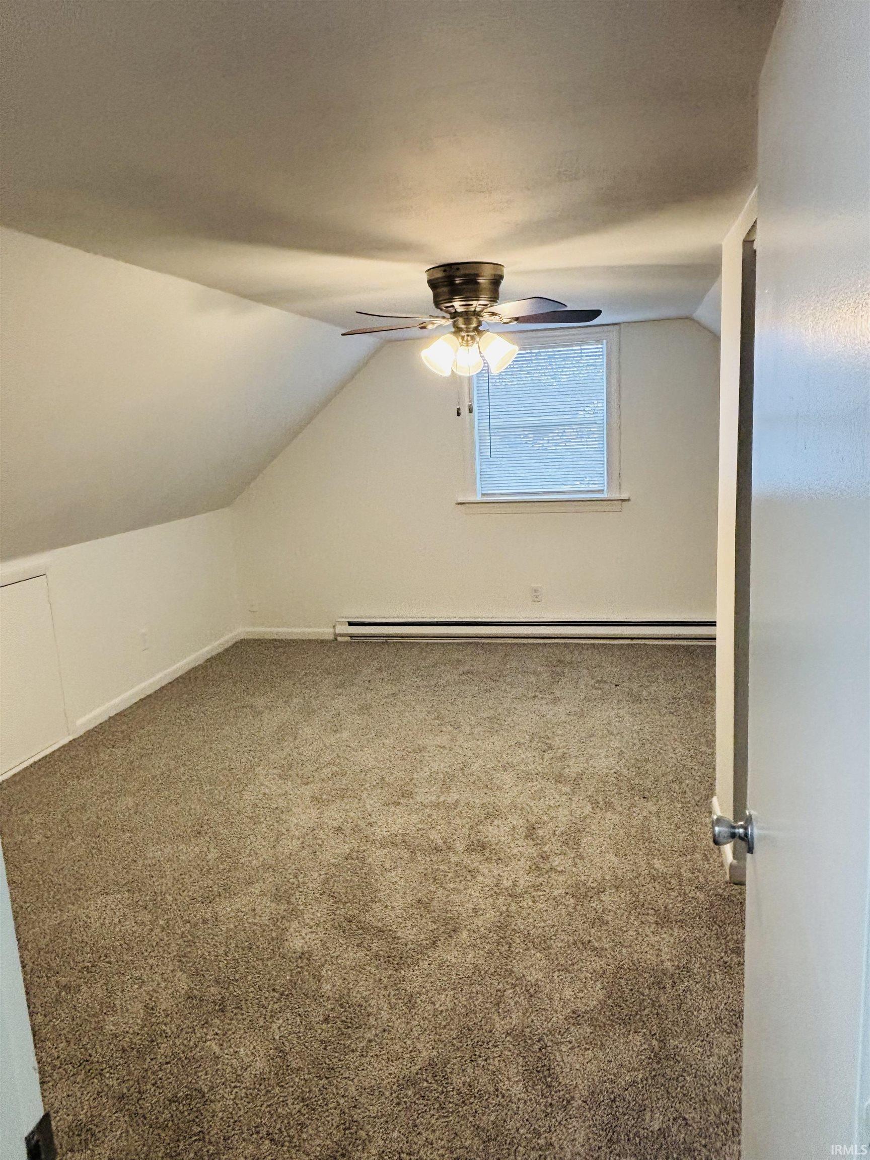 Bonus room featuring carpet, lofted ceiling, a ceiling fan, and a baseboard radiator