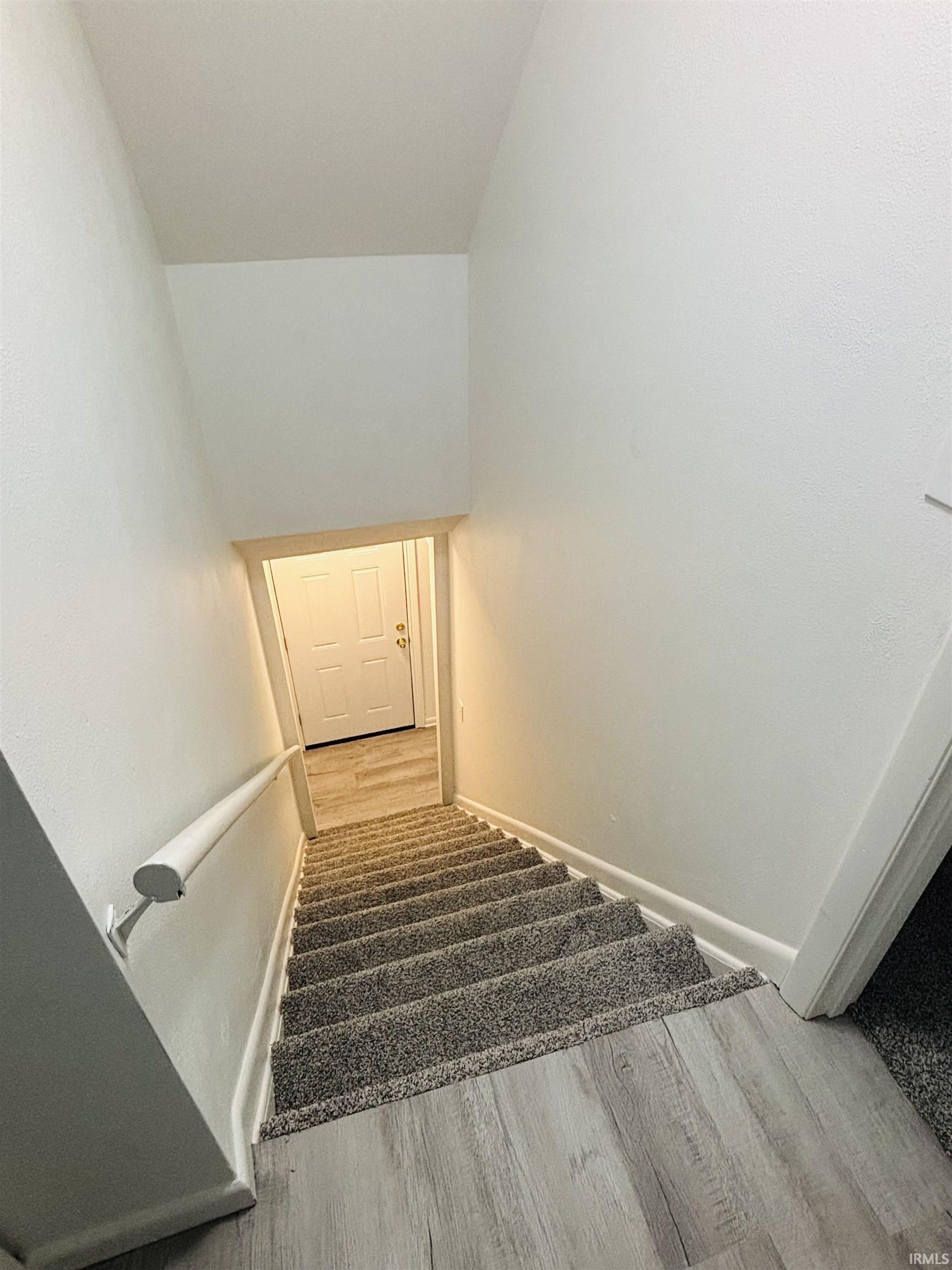 Staircase featuring wood finished floors and baseboards