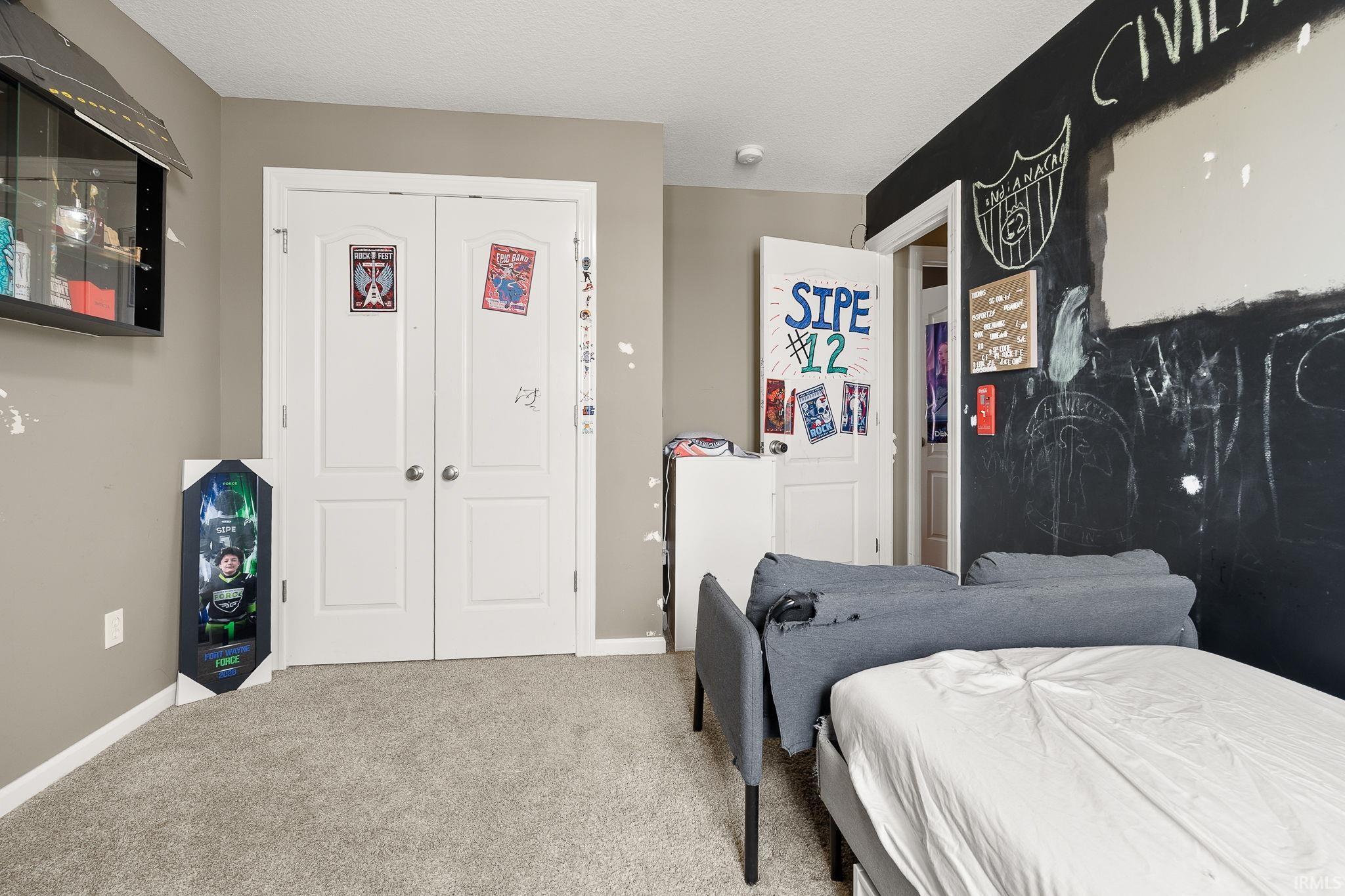 Bedroom featuring a closet, carpet flooring, and a textured ceiling