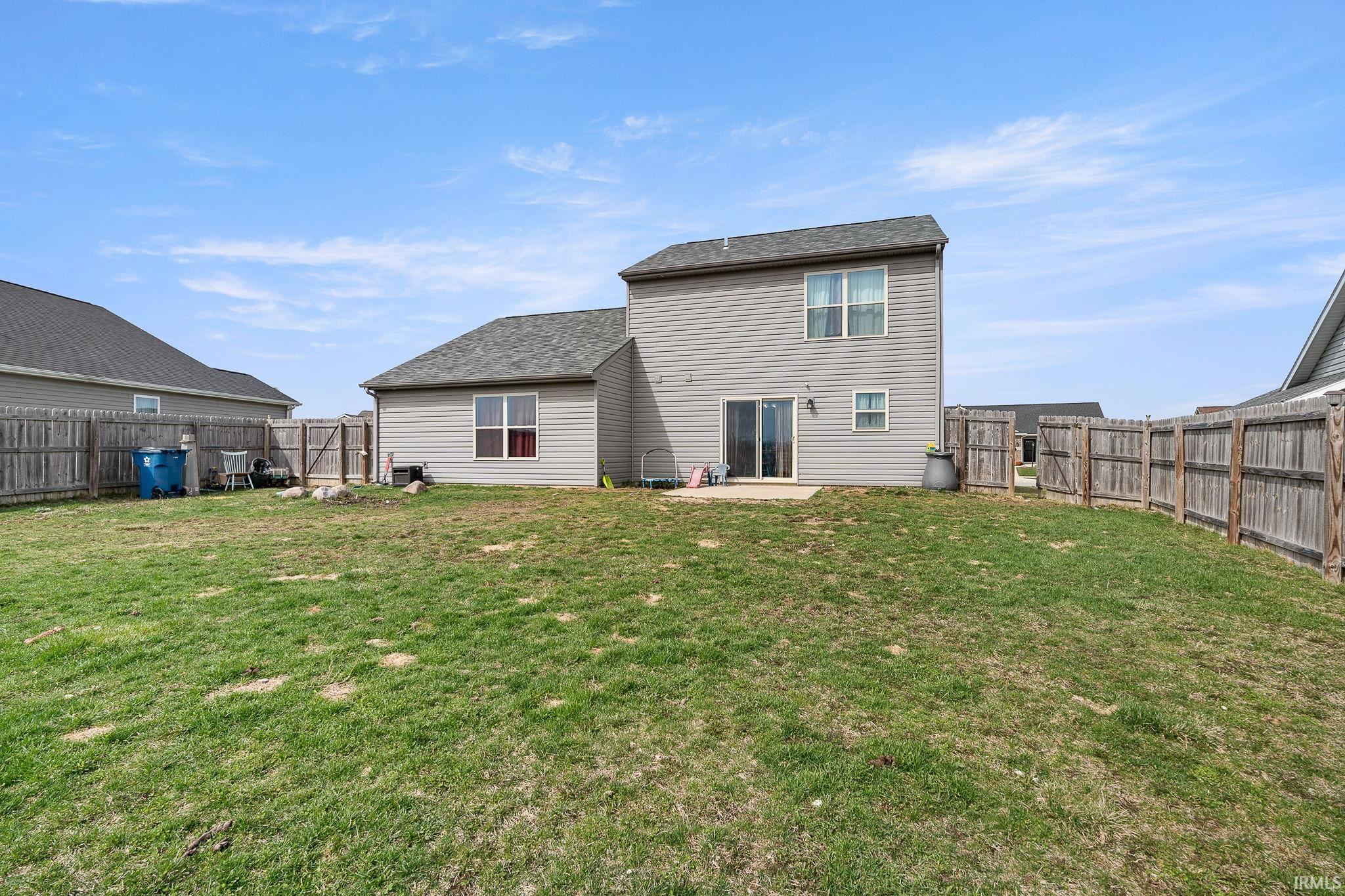 Rear view of house featuring a patio and a fenced backyard