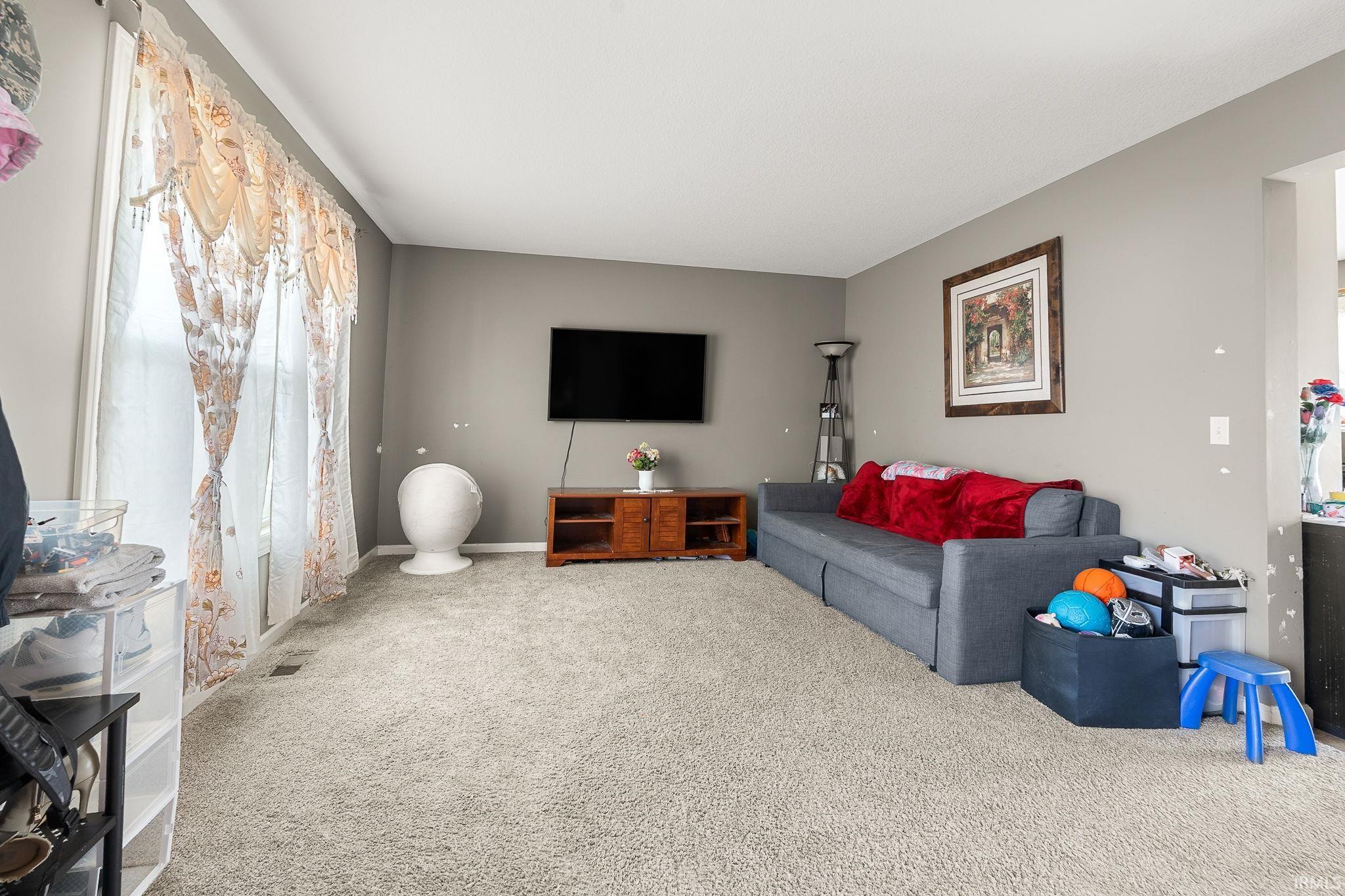 Carpeted living room featuring baseboards