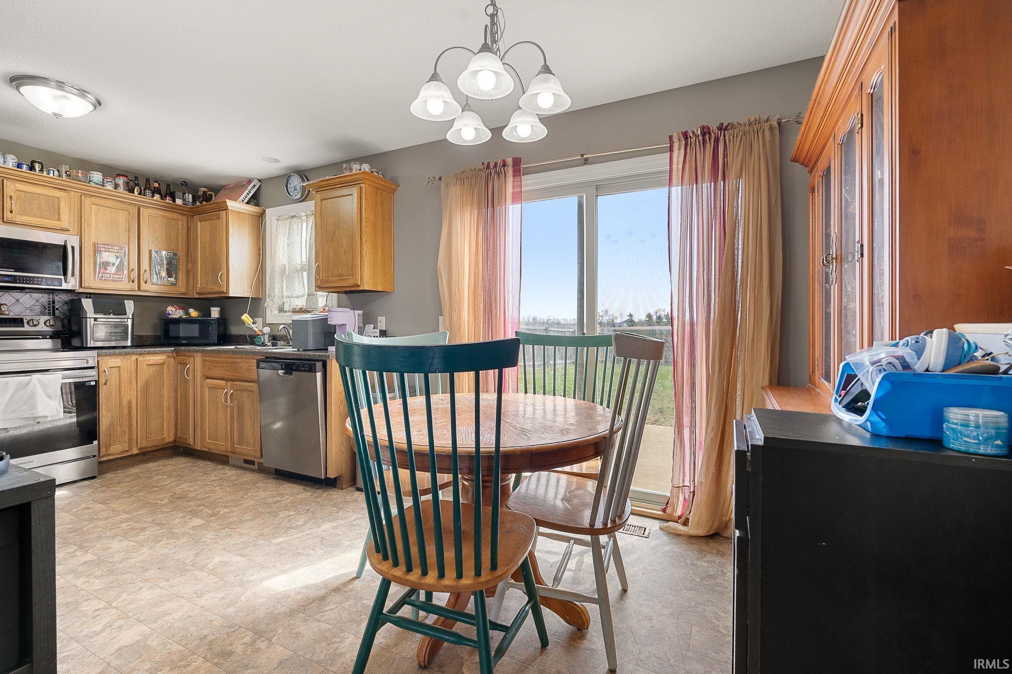Kitchen featuring stainless steel appliances, wood finish cabinets, hanging lights, and plenty of natural light