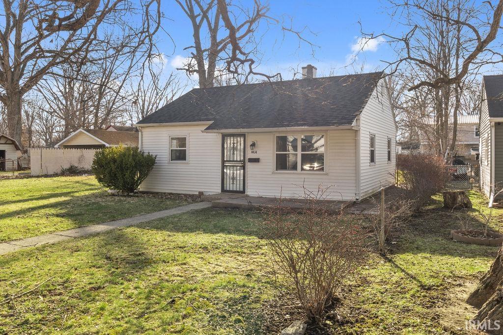 View of front facade featuring a chimney and roof with shingles