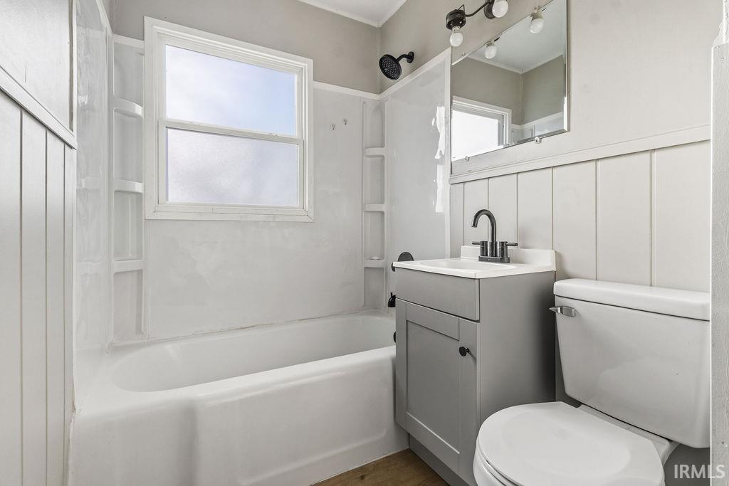 Bathroom featuring vanity, shower / bathtub combination, and a decorative wall