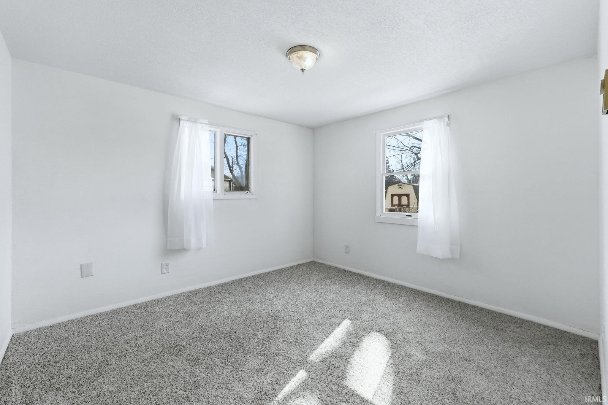 Carpeted empty room with baseboards