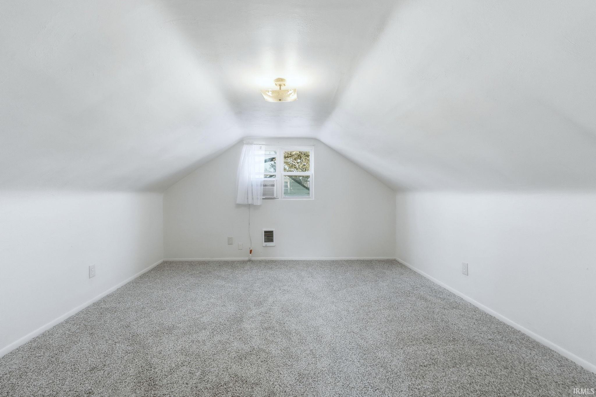 Additional living space featuring baseboards and carpet flooring