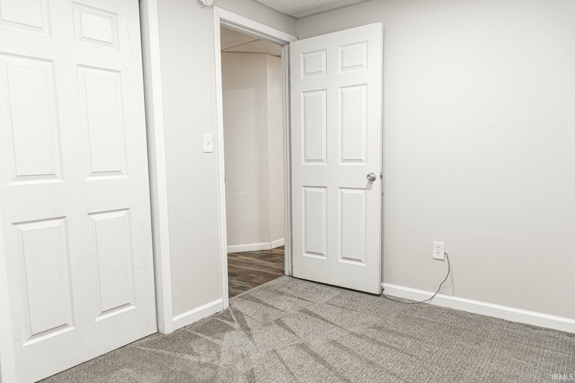 Unfurnished bedroom with light colored carpet and a closet