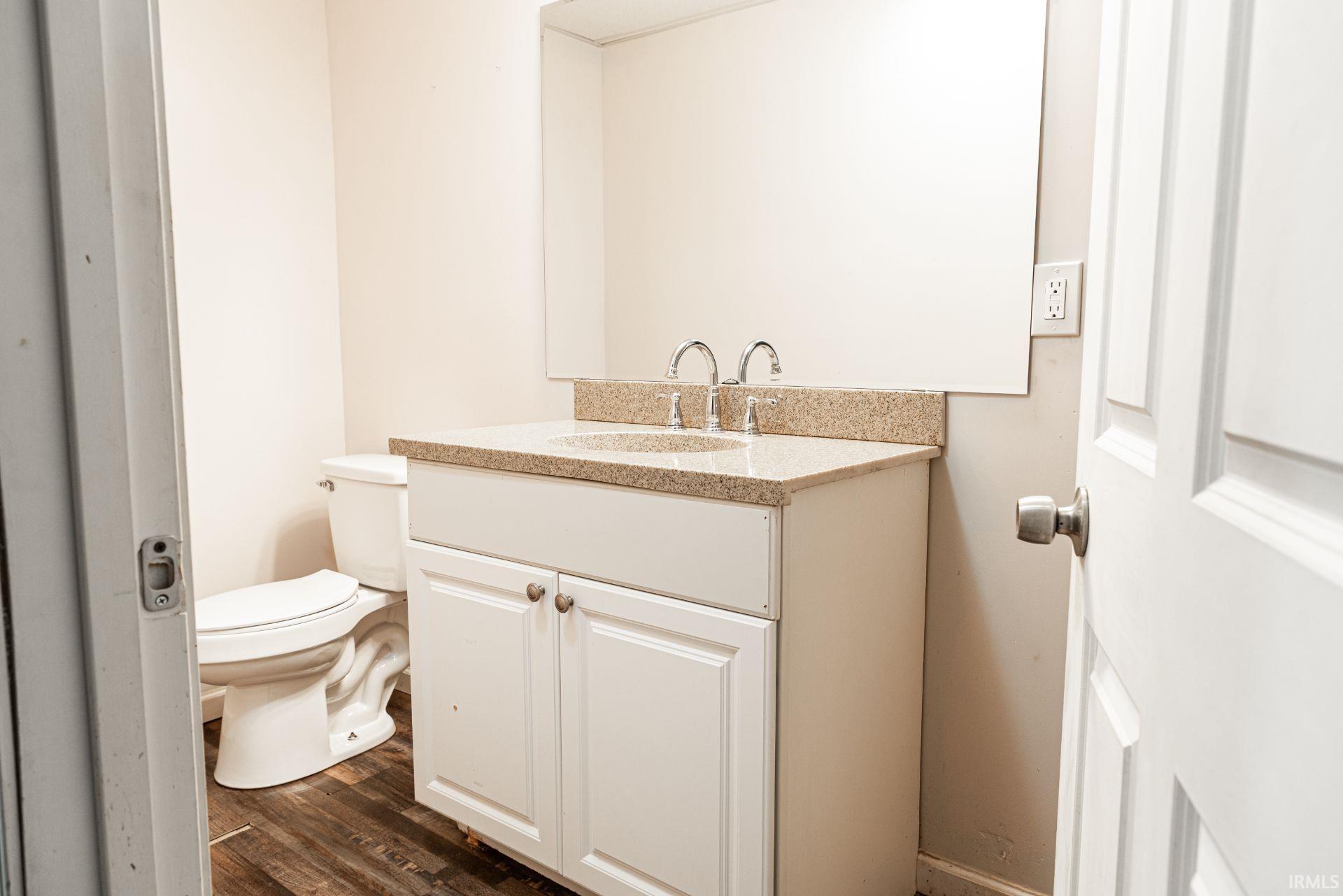 Bathroom featuring vanity and dark wood-style flooring