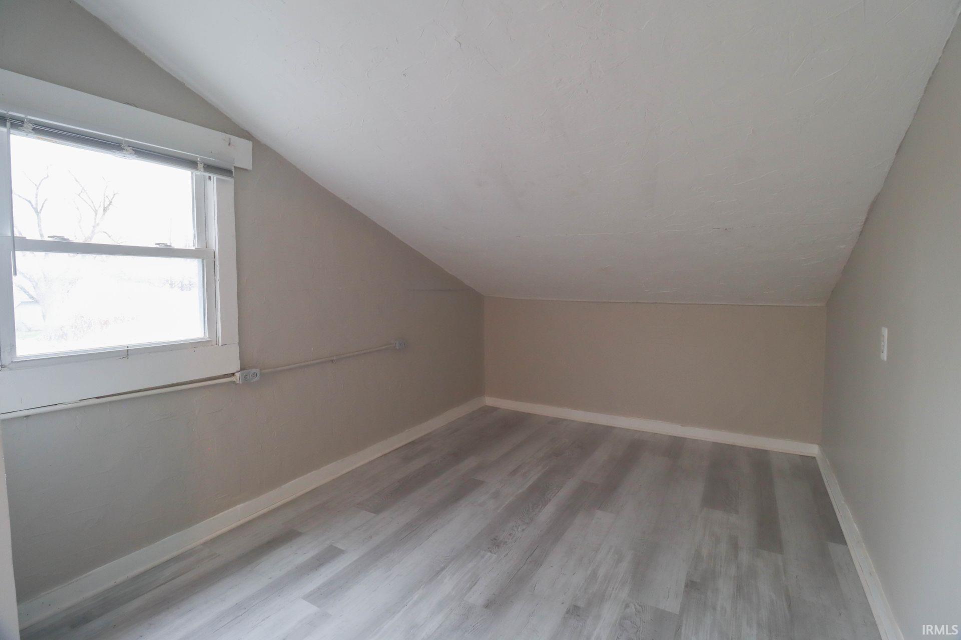 Bonus room featuring light wood-type flooring and lofted ceiling