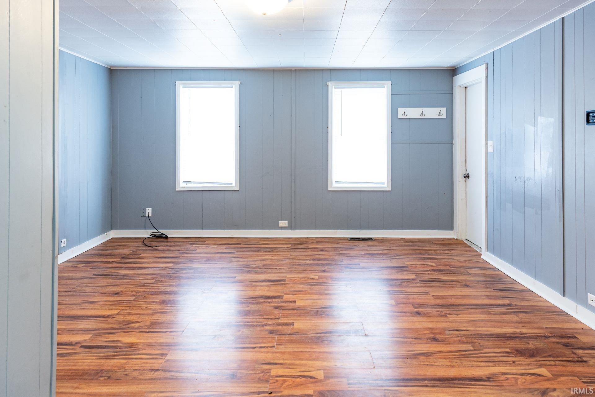 Unfurnished room with dark wood-type flooring and plenty of natural light