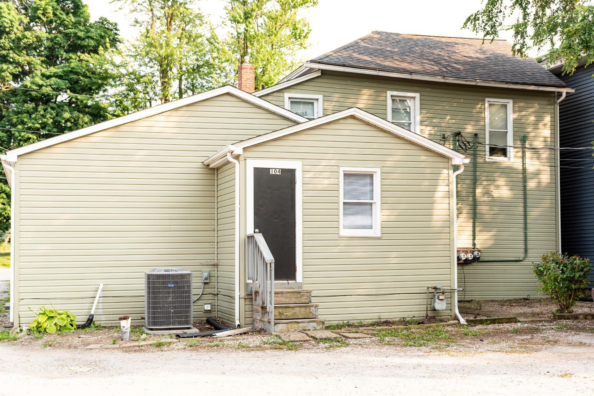 View of front of house featuring entry steps, roof with shingles, and a chimney
