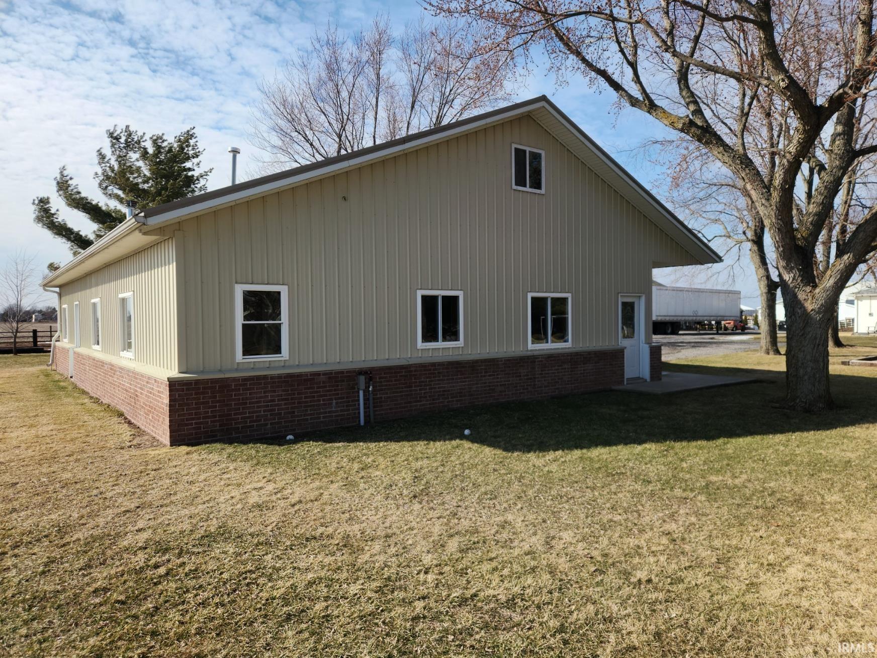 View of property exterior featuring a yard and brick siding