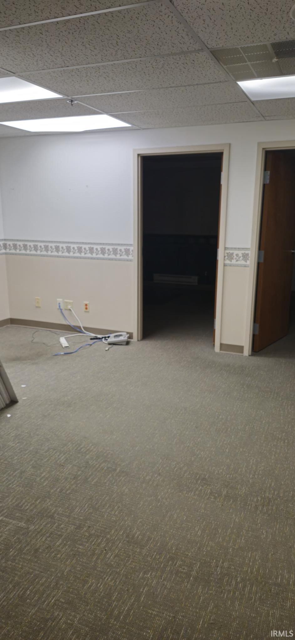 Unfurnished room with a paneled ceiling and carpet floors