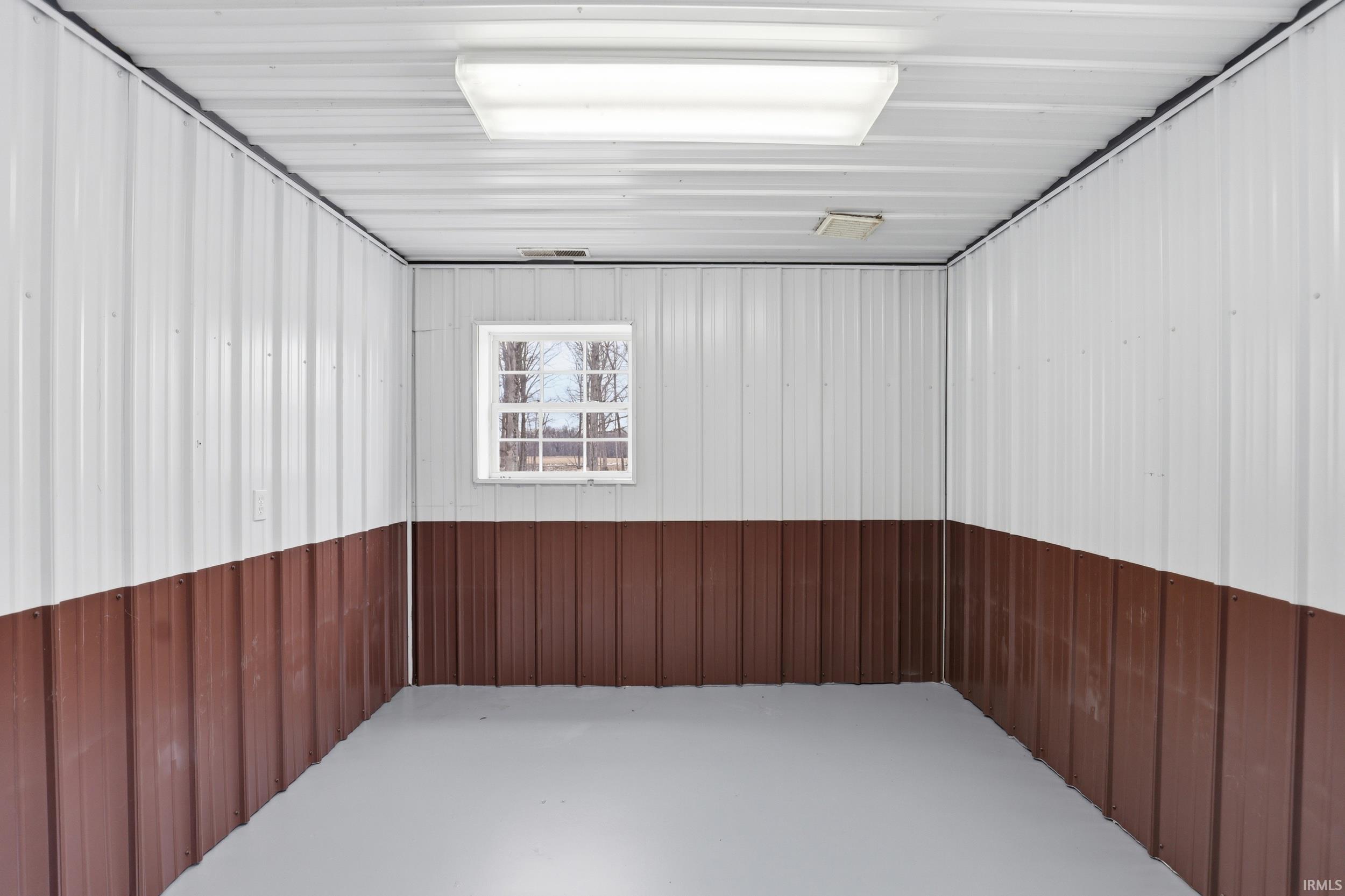 Unfurnished room with concrete floors and metal wall